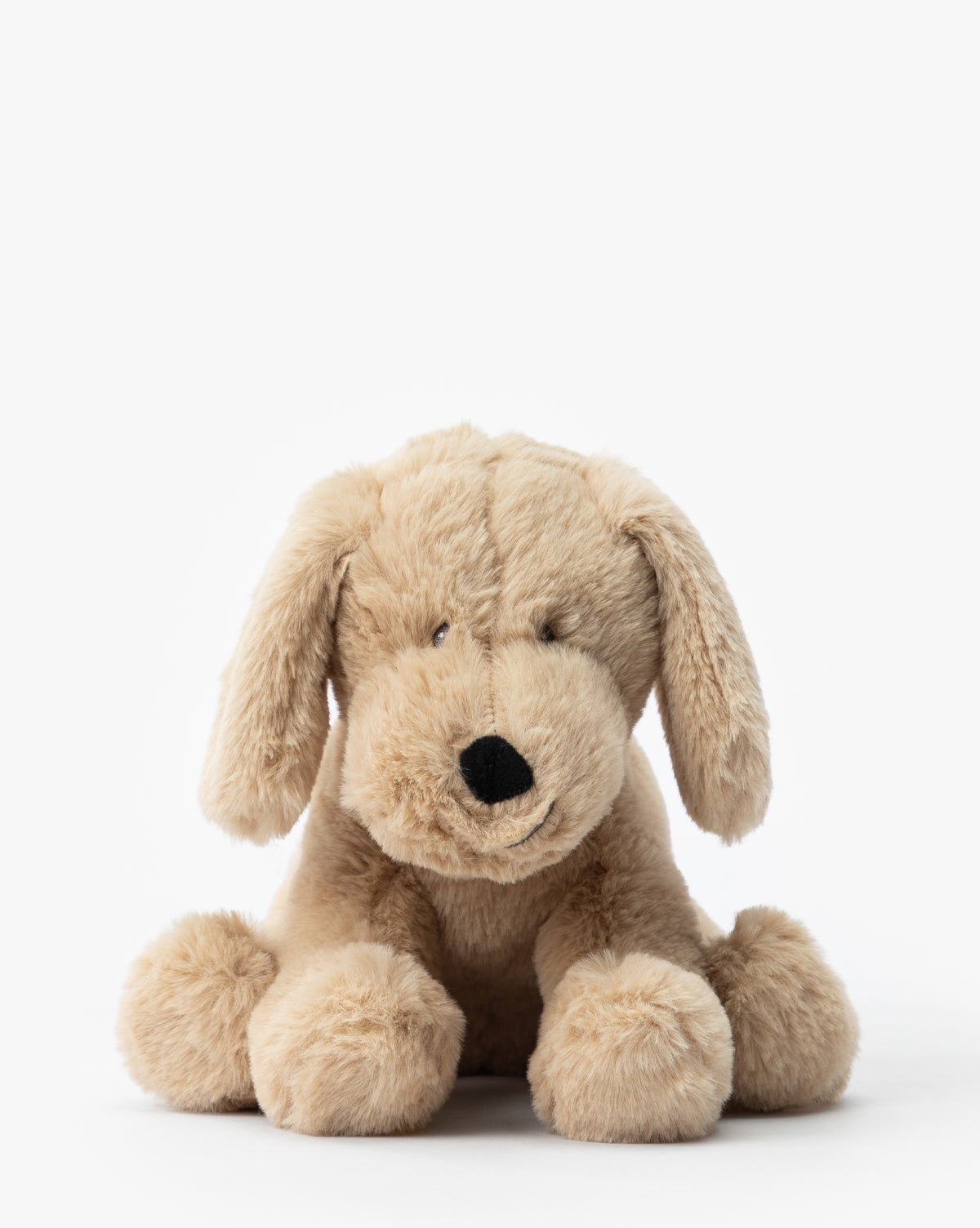 The Hank Plush Pup is a soft, light brown stuffed dog with floppy ears and a black nose. It sits facing forward on a white background—an adorable addition to any childrens room or nursery, by McGee & Co.