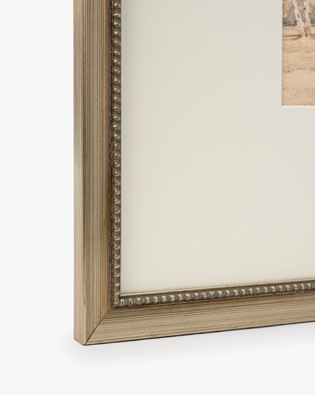 Close-up of the Harewood Park frame corner in distressed silver with a metallic finish and beaded detailing, shown holding matted artwork or a giclee print against a white background, by Vendixs