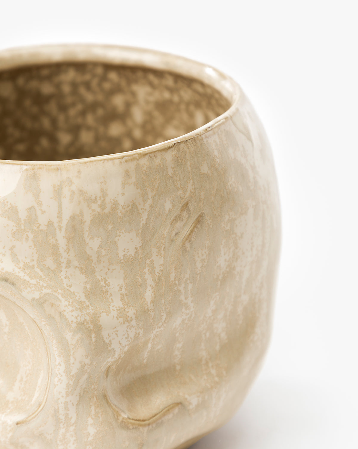Close-up of the Haunting Skull Vase, a beige round ceramic piece with a marbled texture, subtle embossed patterns, and a speckled rim and interior—perfect as a statement Halloween décor accent, by McGee & Co.