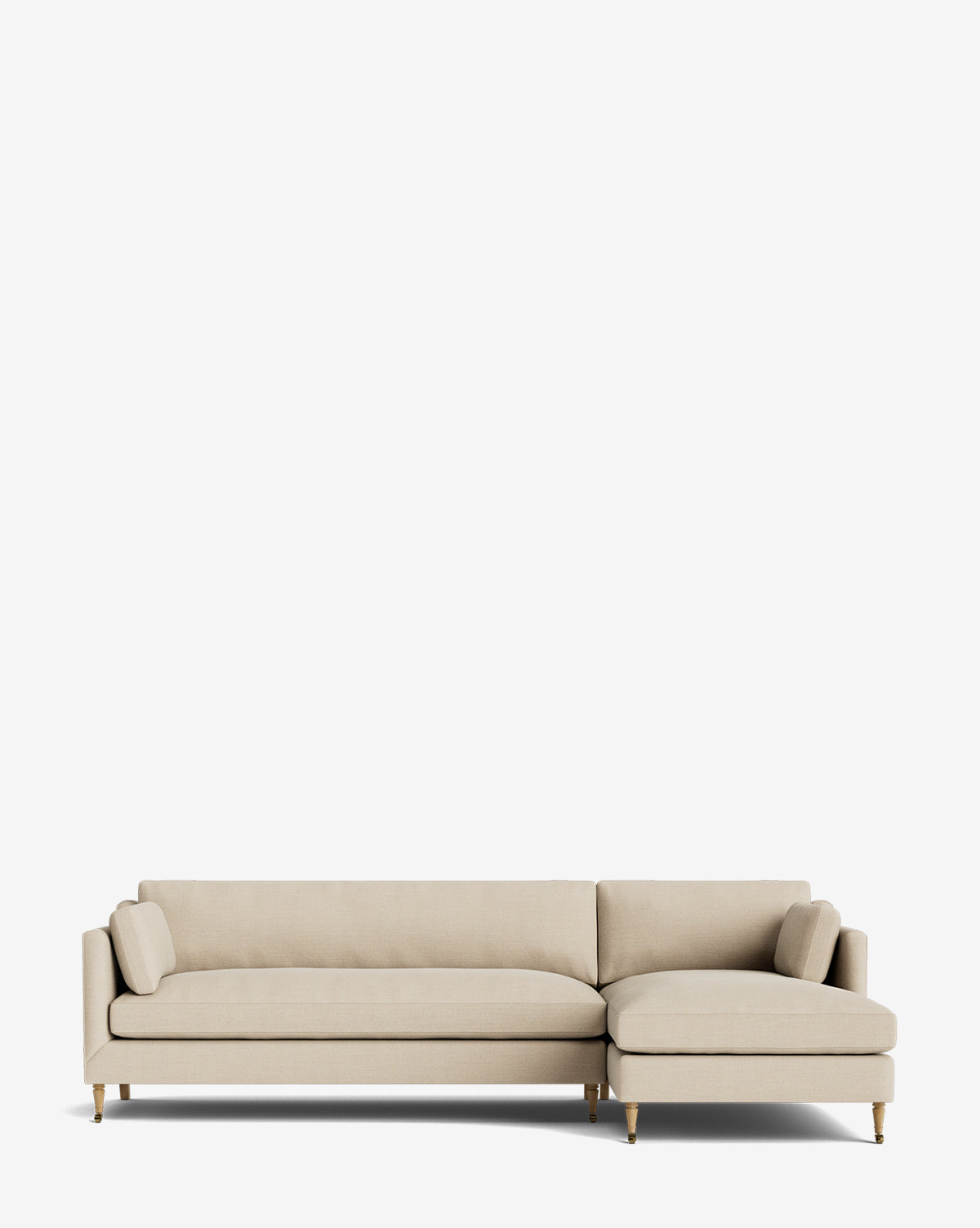 The Haverford Upholstered Right Chaise Sectional by Rowe Fine Furniture features a beige finish, low backrests, two matching cylindrical pillows, and wooden legs with brass accents, shown against a plain white background by Vendixs