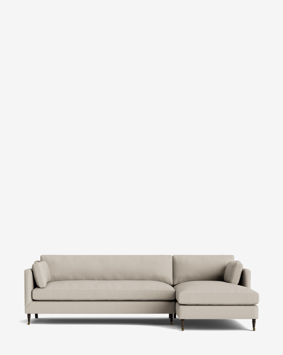 A light beige Haverford Upholstered Right Chaise Sectional 113 with slim armrests, two matching bolster pillows, and wooden legs is shown against a plain white background, by Vendixs