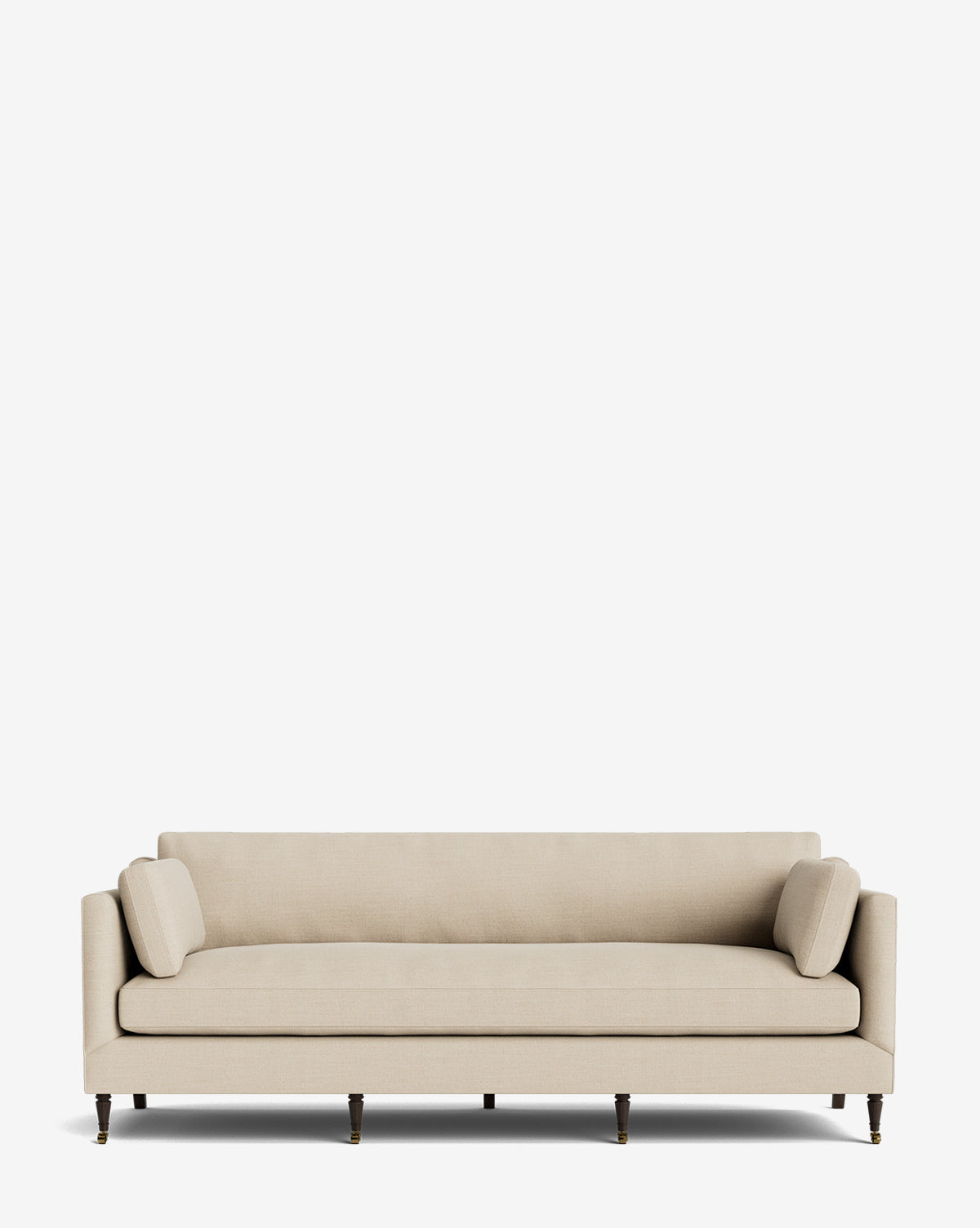 The Haverford Upholstered Sofa 90 is a beige, modern three-seater featuring clean lines, two matching cylindrical bolster pillows, and dark wooden legs with brass castors—handcrafted and set against a plain white background by Vendixs