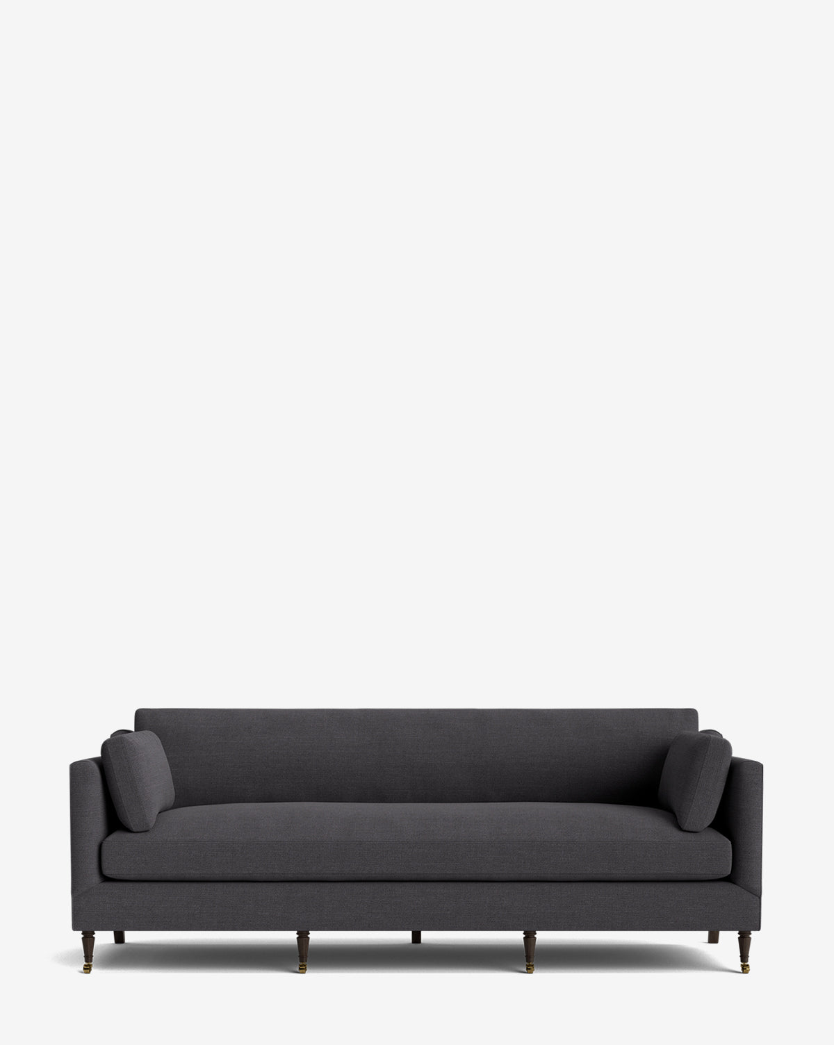 The Haverford Upholstered Sofa 90 features a modern dark gray design with two cylindrical bolster pillows and slim wooden legs, set against a plain white background. This customizable sofa brings timeless elegance to any living space, by McGee & Co.