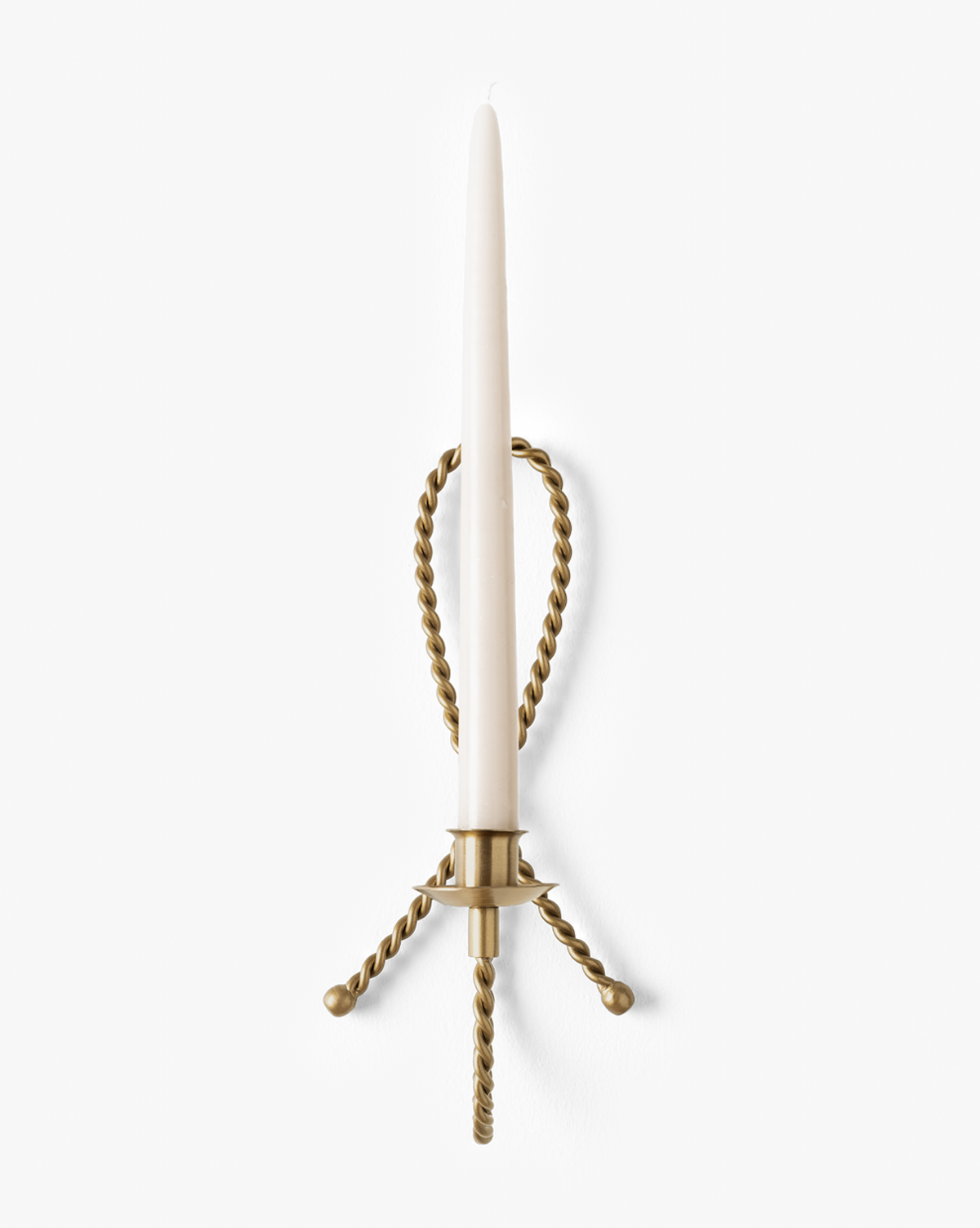 The Hearst Taper Holder is a sculptural brass wall sconce with twisted metal arms that holds a tall, slender white candle upright against a plain white background, by Vendixs
