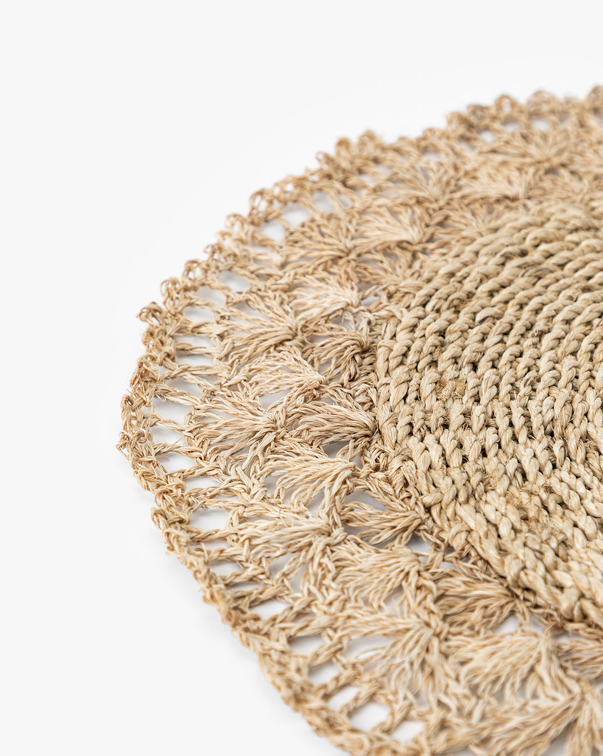 Close-up of the Hermione Placemat, a round design with an intricate, lacy crochet-inspired edge, set against a white background, by Vendixs