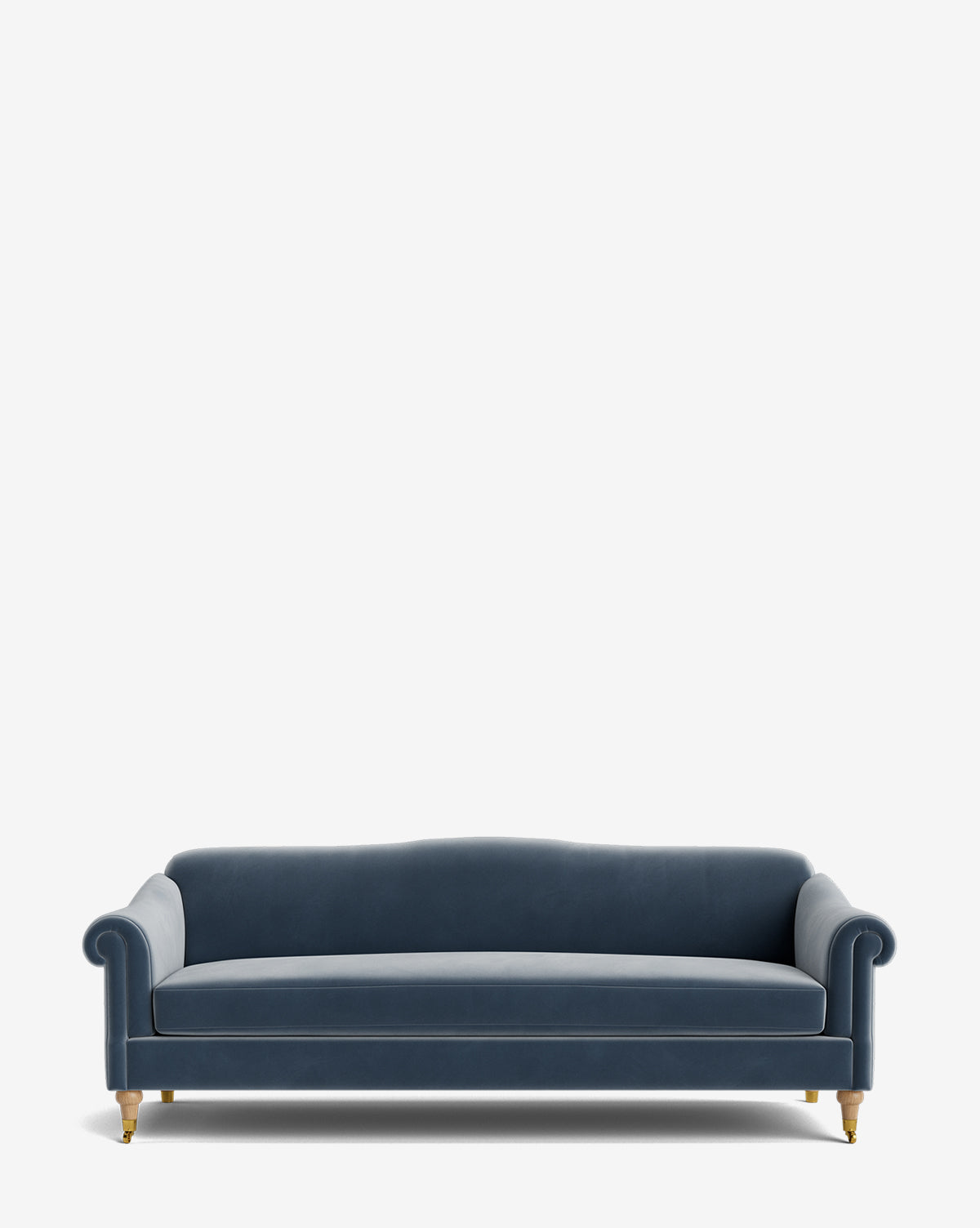 The Hildegard Sofa 90 is a blue velvet handcrafted sofa with rolled arms, a gently curved back, and wooden legs with brass casters, shown against a plain white background by Vendixs
