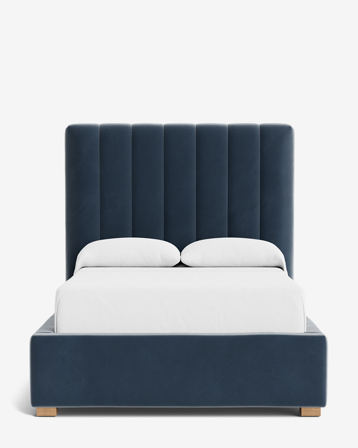 The Hoffman Bed Tall Headboard showcases vertically paneled dark blue upholstery, a matching frame, white bedding, and two white pillows—set against a plain white background. Customizable fabric options available, by McGee & Co.