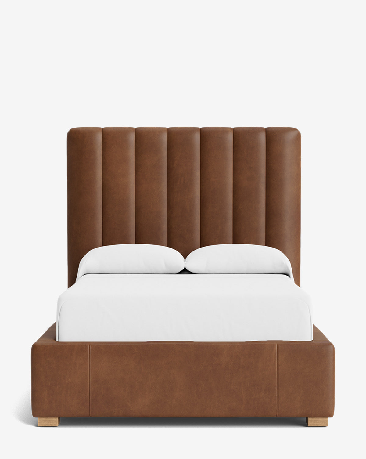 The Hoffman Bed Tall Headboard features vertical channeled brown leather and a matching frame, styled with white bedding and two pillows. Personalize this modern bed by choosing from a variety of fabric options, by McGee & Co.
