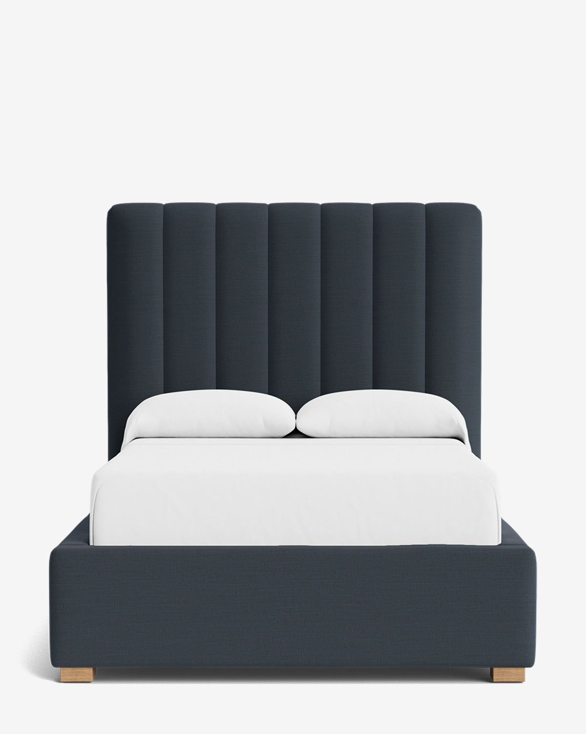 The Hoffman Bed Tall Headboard features vertical channels and navy blue upholstery for a modern look. Its matching frame allows fabric customization, while crisp white bedding and pillows complete the stylish ensemble by McGee & Co.