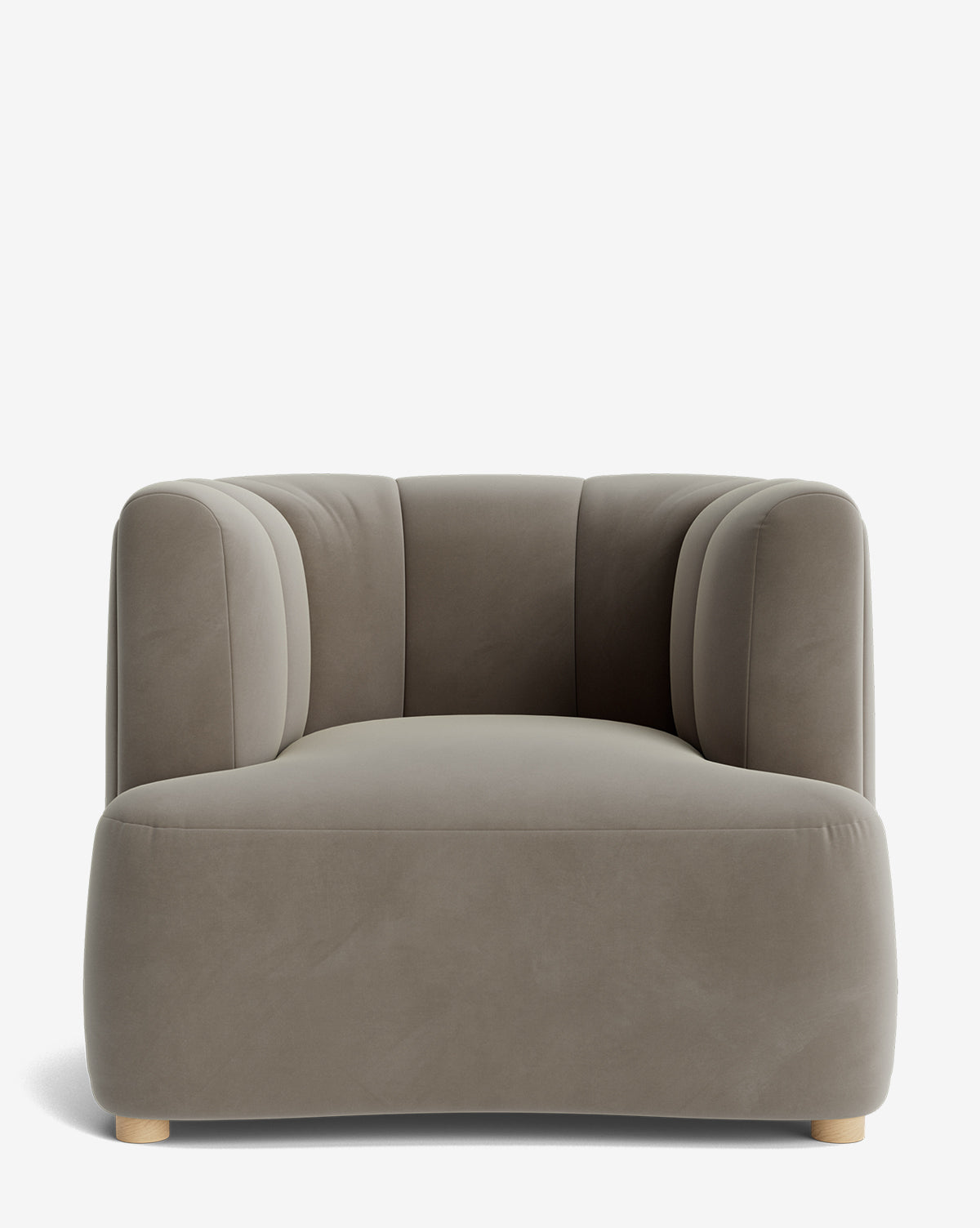The Ines Lounge Chair is a wide, modern chair with soft, rounded edges and light gray velvet upholstery. It features subtle vertical tufting on the backrest and short, light wooden legs for a plush, inviting look, by McGee & Co.
