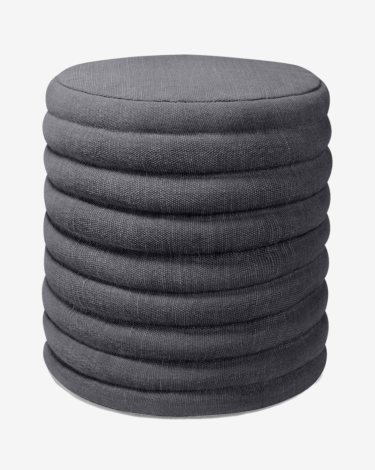 The Jefferson Stool by Made Goods is a round, dark gray fabric ottoman with a ribbed, layered design inspired by mid-century style, shown against a plain white background. Vendixs