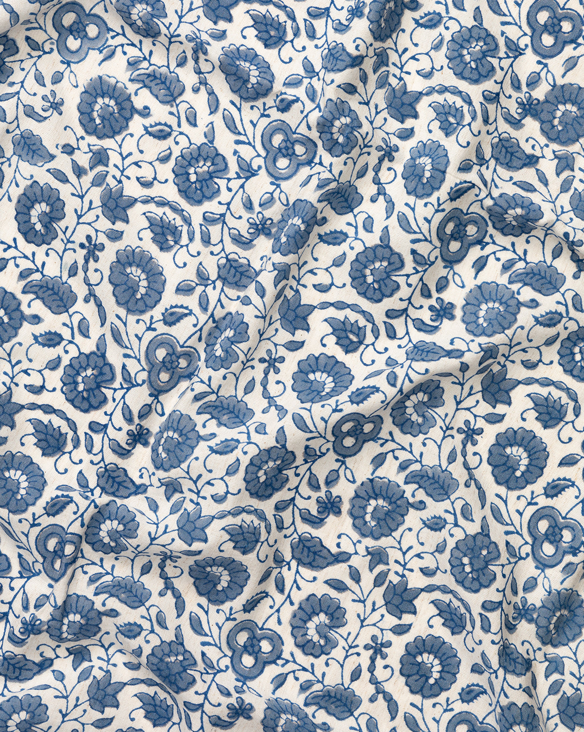 The Jennie Tablecloth features a white fabric with an intricate blue floral pattern of flowers, leaves, and vines, by Vendixs