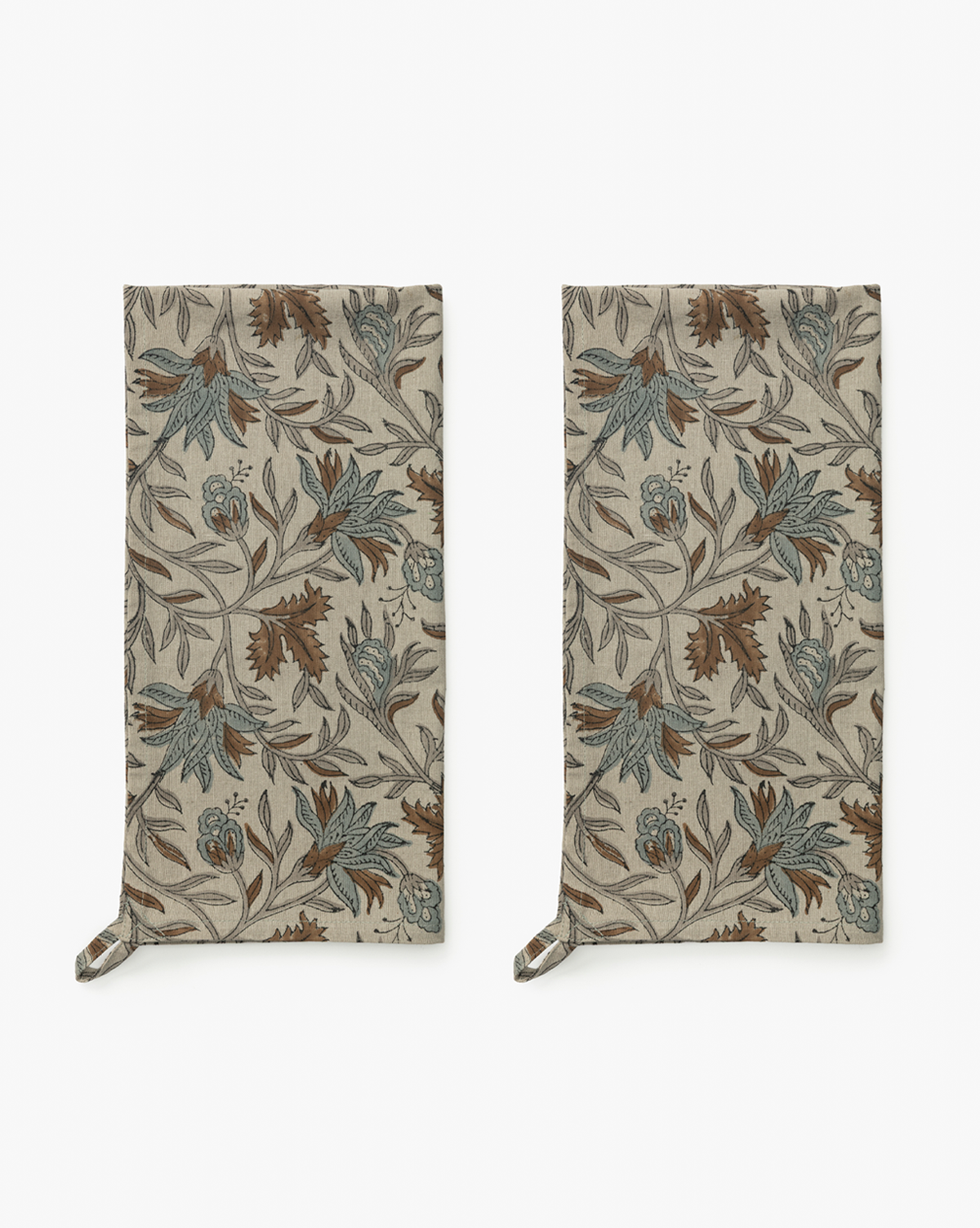 The Jennifer Block Print Tea Towels (Set of 2) are beige cotton towels with a brown, blue, and green floral pattern and corner hanging loops, displayed side by side on a white background, by Vendixs