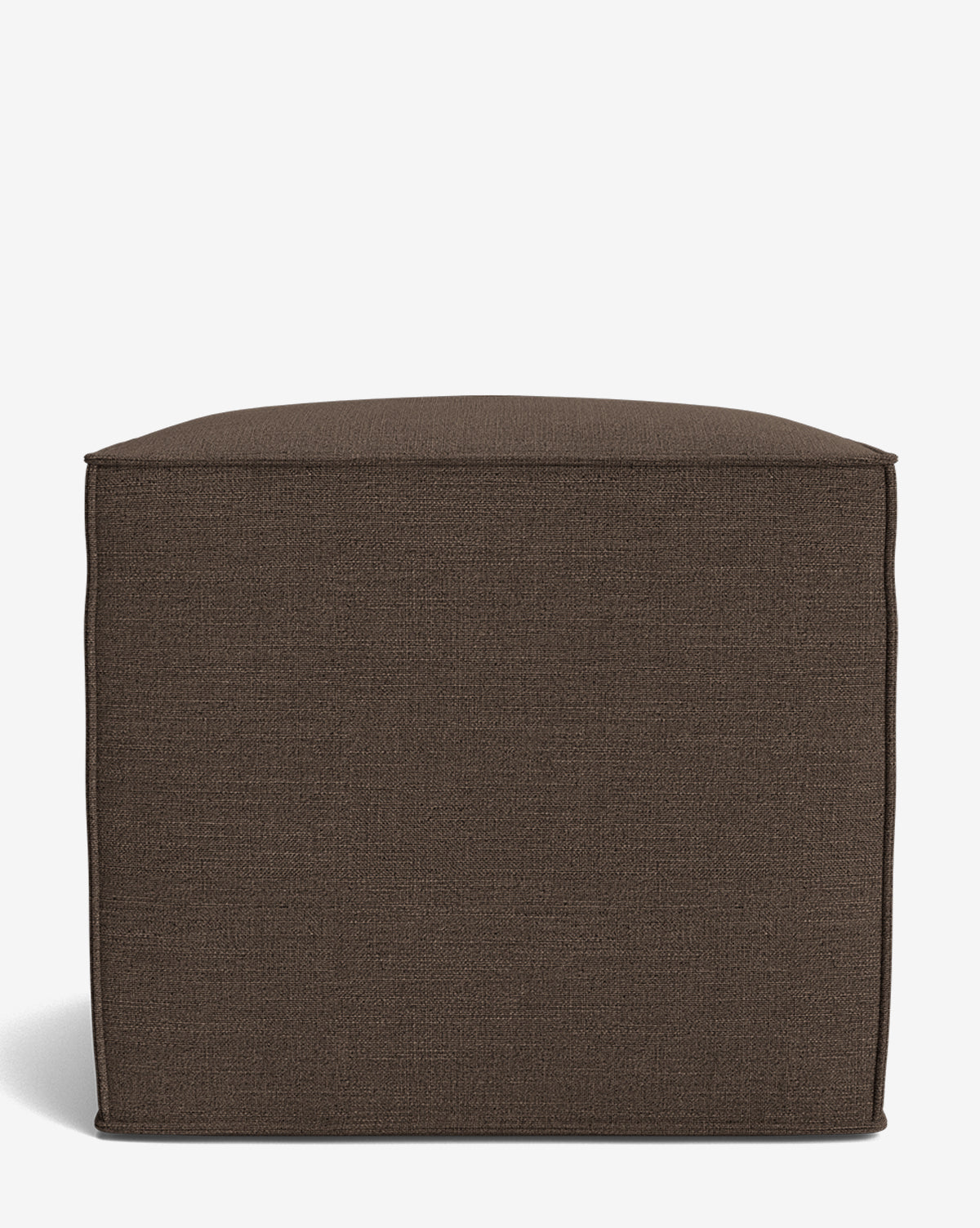 The Johannes Cube is a square, dark brown fabric ottoman with a cushioned seat and minimalist boxy design. Shown on a plain white background, this made-to-order piece brings comfort and style to any room, by McGee & Co.