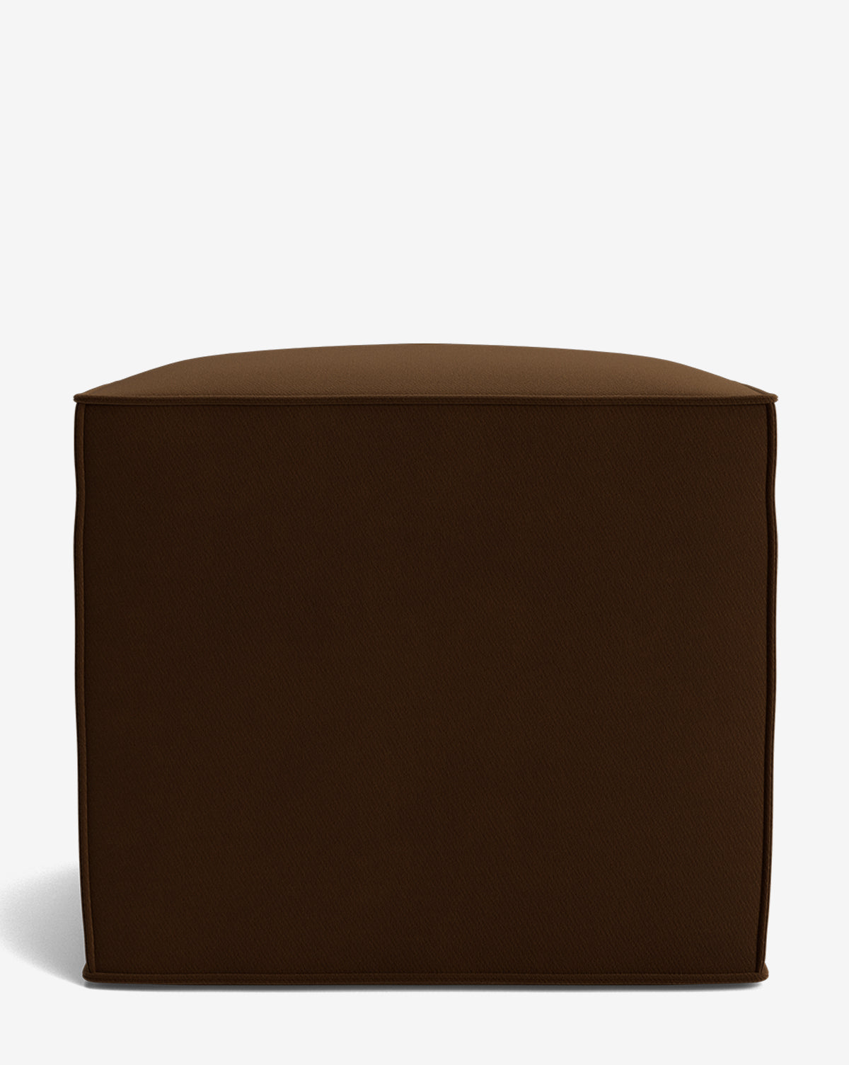 The Johannes Cube is a square, dark brown fabric ottoman with a cushioned seat and rounded edges. Shown on a plain white background, this made-to-order piece adds comfort and style to any room, by Vendixs