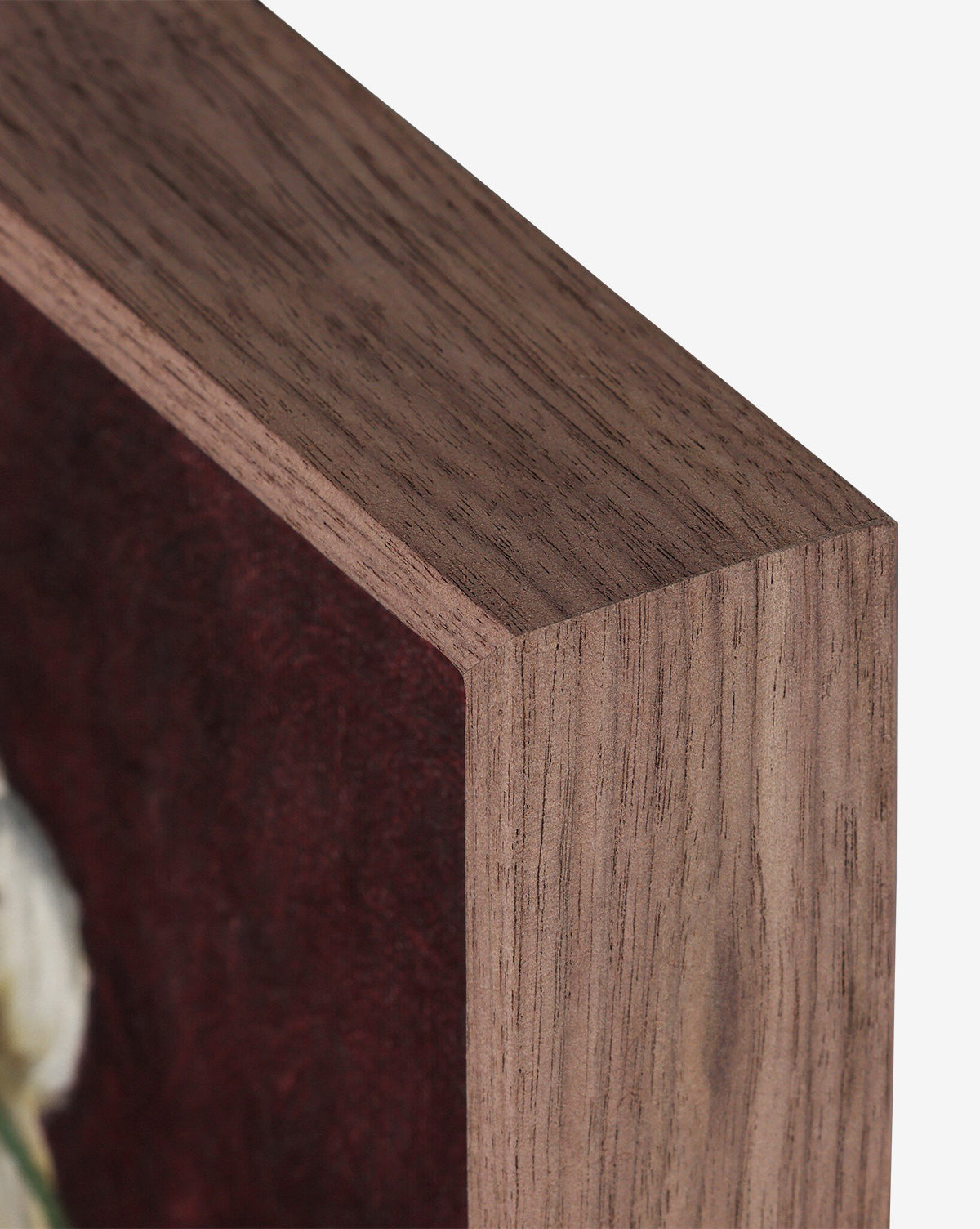 Close-up of a walnut-finish wooden frame, handmade in Austin, displaying Jubilee by Bethany Joseph with part of a burgundy and white artwork visible inside, by Vendixs