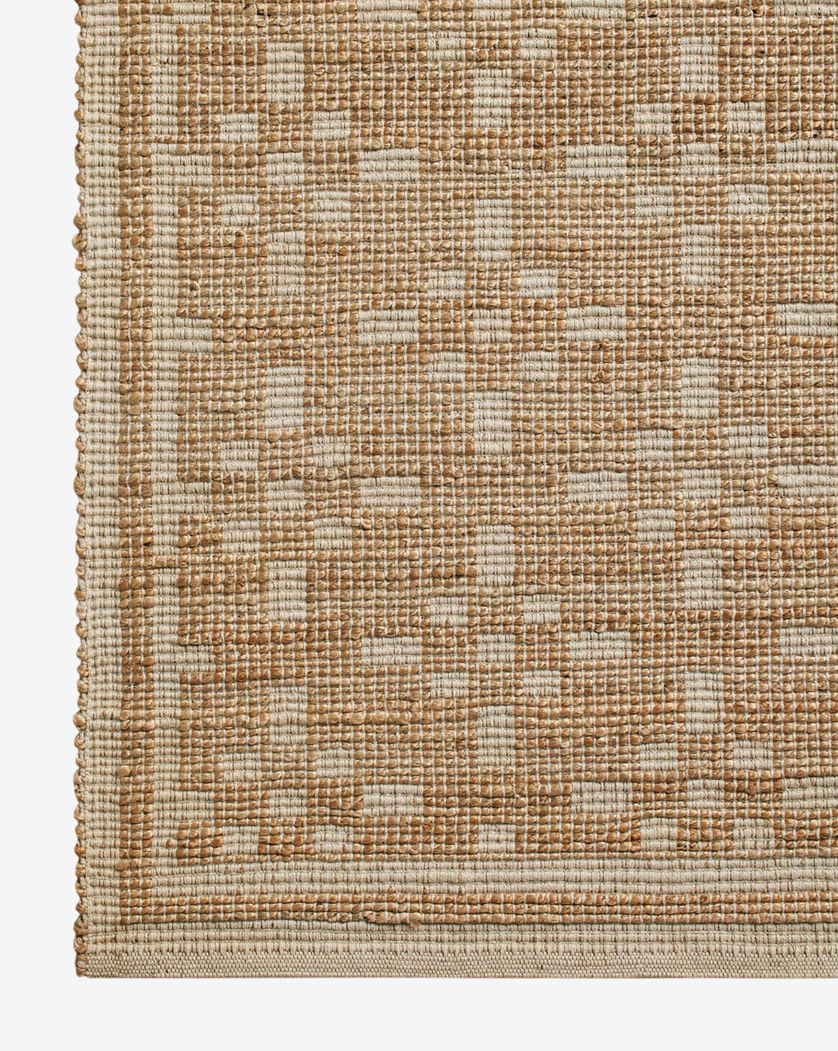 Close-up of a handwoven rug's corner with a geometric pattern in beige and light brown, featuring a textured grid design and bordered edge—highlighting the elegance of the Judy Ivory Jute Rug Collection No. 7, by Vendixs