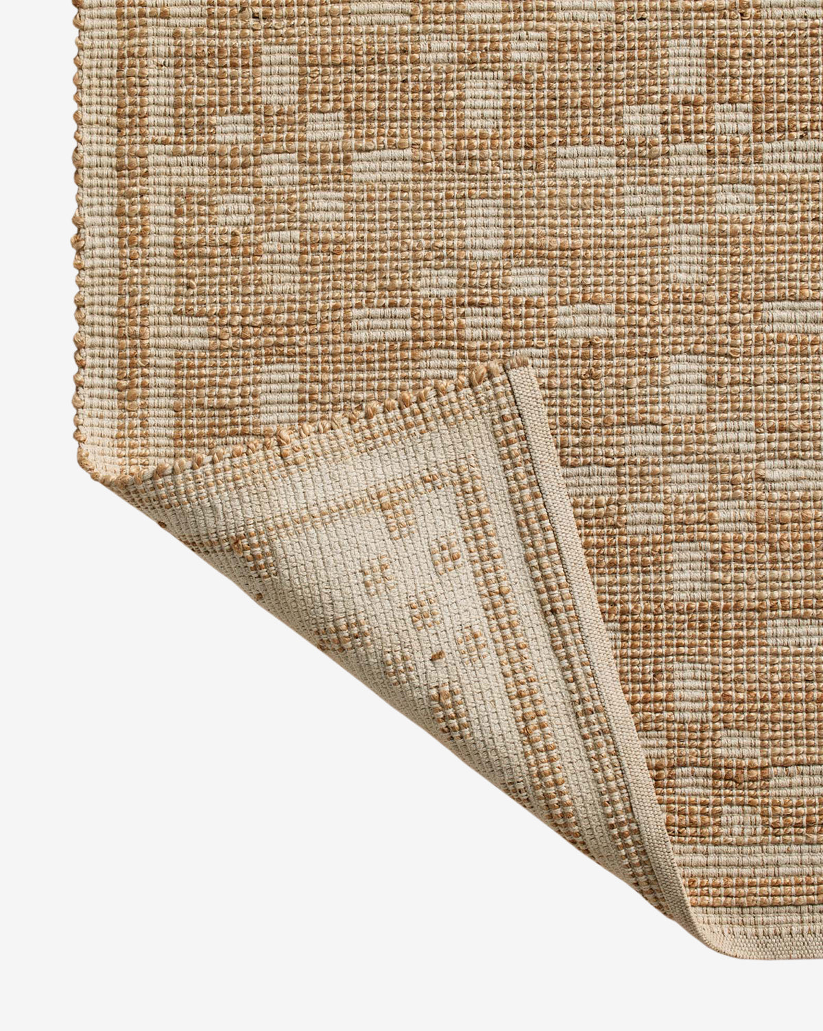 A close-up of the Judy Ivory Jute Rug Collection No. 7 reveals a handwoven geometric beige and brown pattern, with one corner flipped to show the textured underside—showcasing the quality and durability of this area rug, by Vendixs