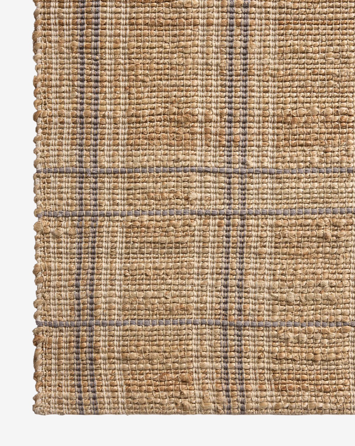 Close-up of the Judy Jute Rug Collection No. 2, a handwoven rug in tan and beige with thin blue and gray lines forming a simple, textured plaid grid pattern, by Vendixs