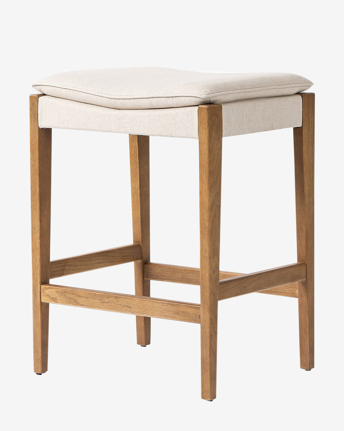 The Kaelith Counter Stool by Four Hands features a solid oak frame, light beige cushioned seat, and four straight legs with support bars. Its simple modern design and light wood finish suit any kitchen countertop. Vendixs