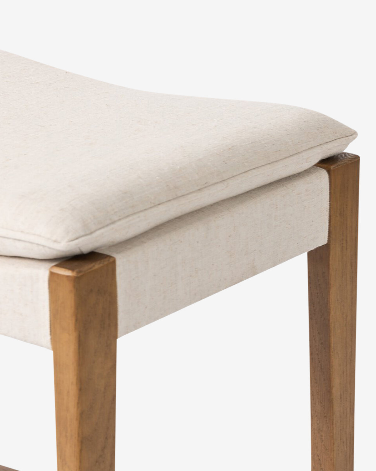 The Kaelith Counter Stool by Four Hands features light beige fabric upholstery, a padded seat cushion, and a solid oak frame—ideal for complementing your kitchen countertop. Vendixs