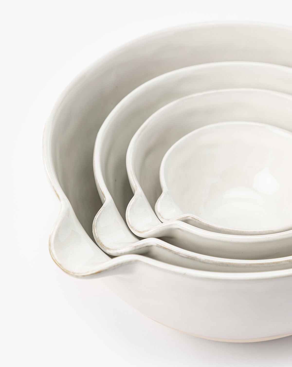 The Karina Stoneware Batter Bowls (Set of 4) nest together in graduated sizes, each featuring a pouring spout and subtle vintage baking charm, displayed against a white background, by Vendixs