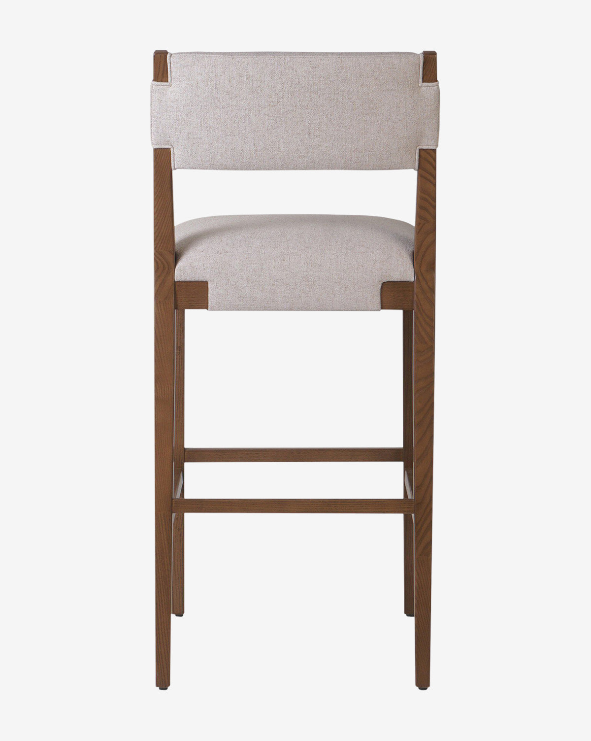 The Kennebec Stool by Four Hands features a tall ash frame with a light beige performance fabric seat and backrest, shown from the back against a plain white background—ideal as a stylish kitchen stool. Vendixs