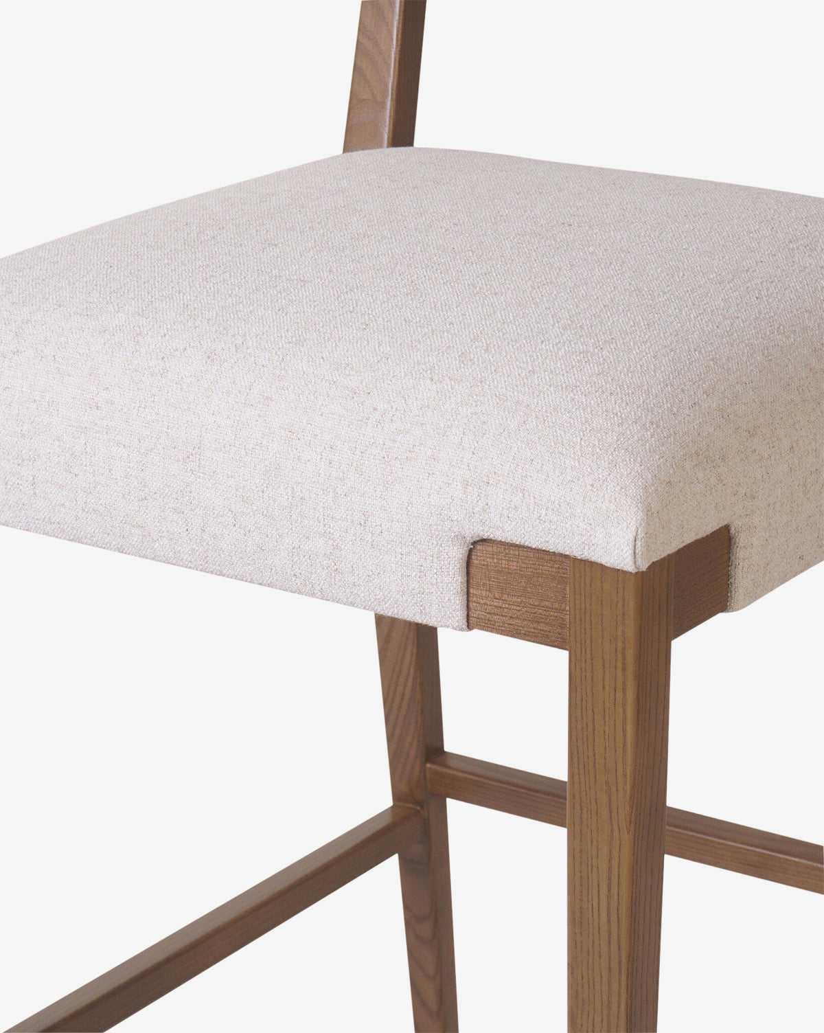 The Kennebec Stool by Four Hands features a modern ash frame with a natural finish, light beige performance fabric seat, clean lines, and visible joinery—showcasing minimalist design in any kitchen setting. Vendixs