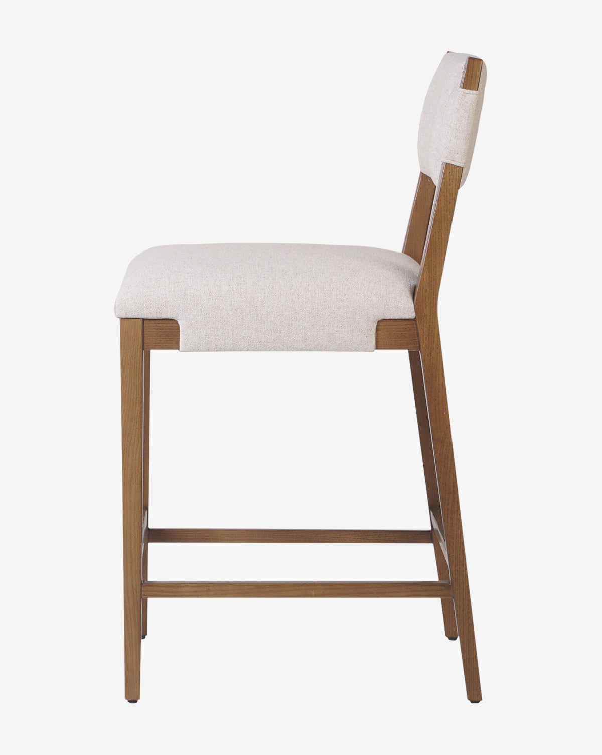 The Kennebec Stool by Four Hands features an ash frame, beige performance fabric seat and backrest, a footrest bar, and a sleek modern design—making it a stylish addition to any kitchen from Vendixs