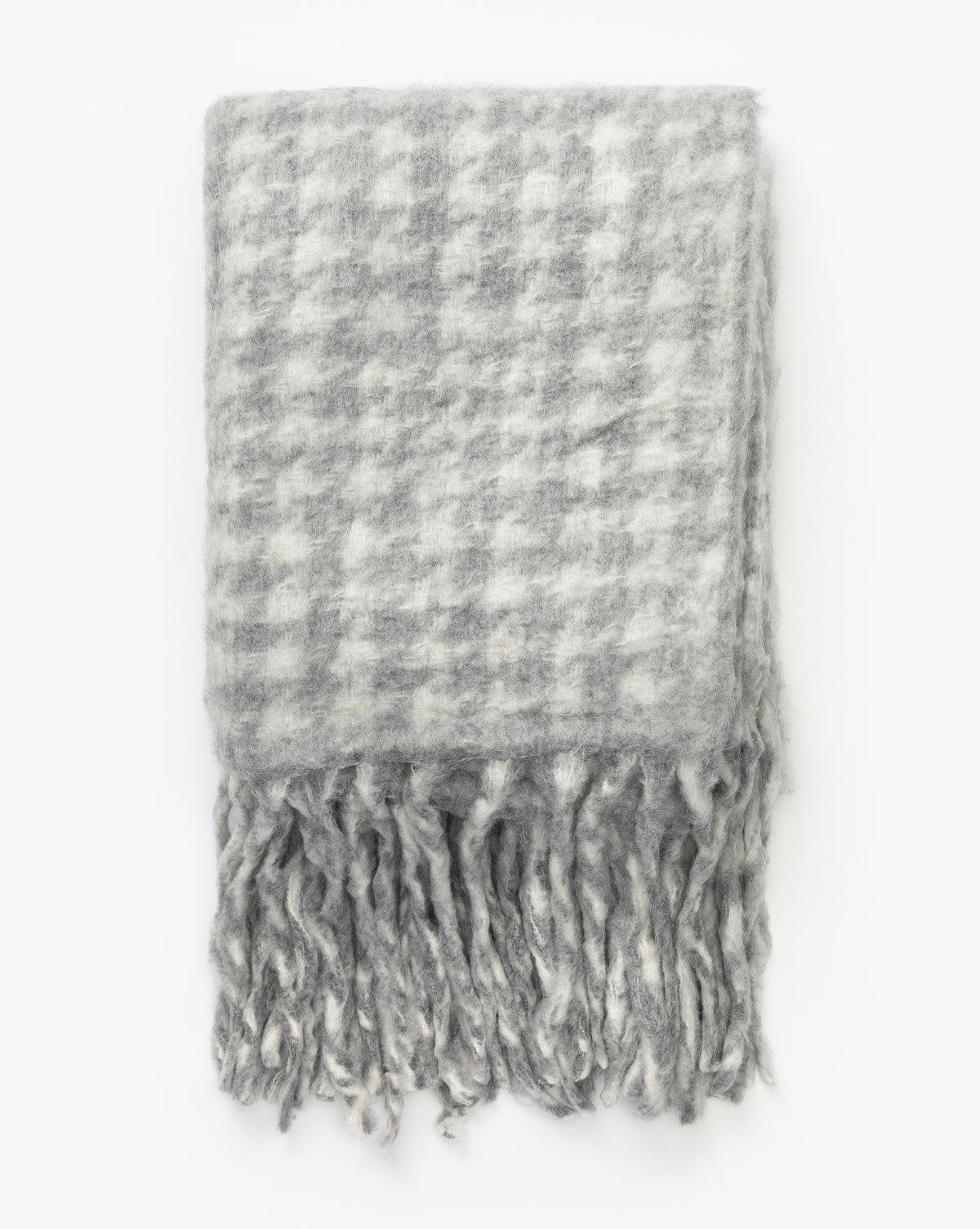 The Indaba Kirsley Houndstooth Throw is a soft wool blend with gray and white houndstooth pattern and long, thick fringes, shown folded against a white background—ideal for luxury home decor. Vendixs
