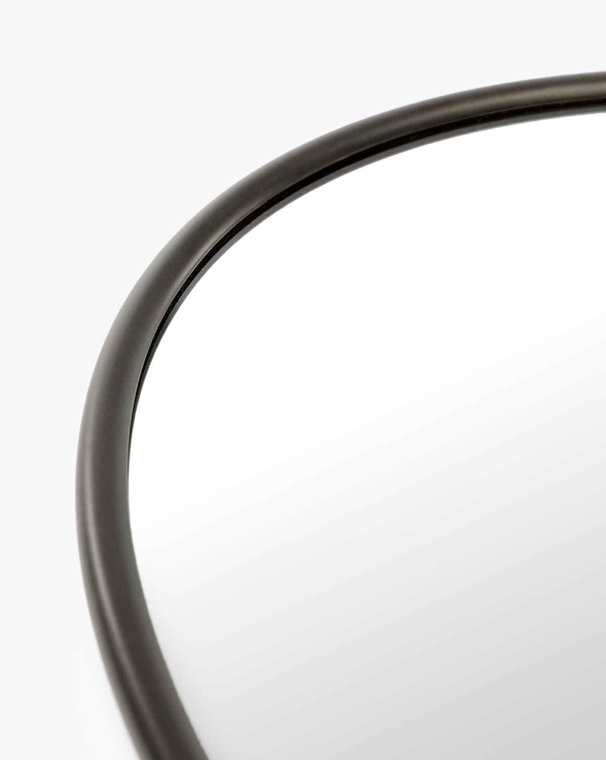 Close-up of the Kitson Oval Mirror’s thin, antique brass frame shown against a white background, by Vendixs