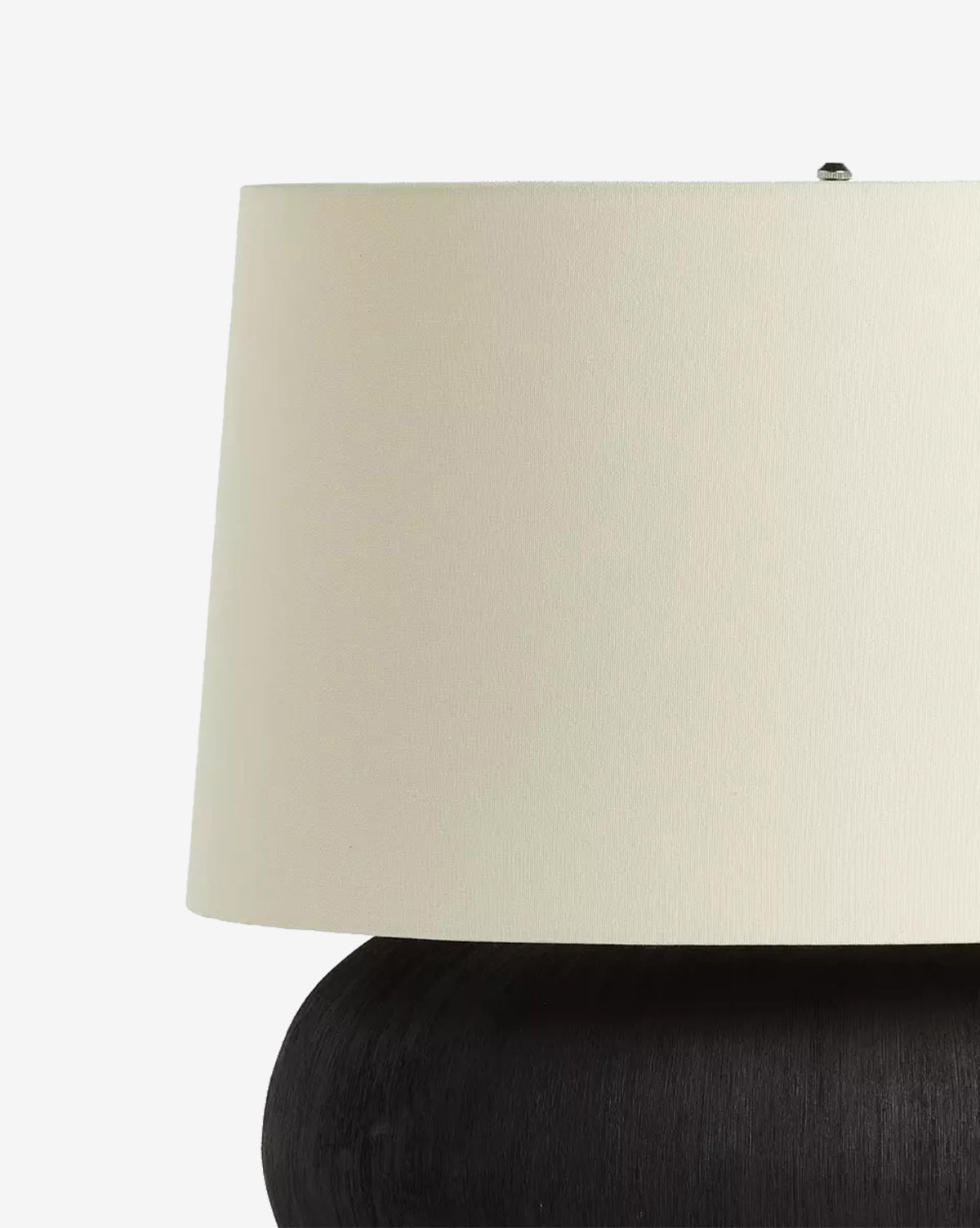 A close-up of the Kragen Table Lamp highlights its ivory linen shade and round dark ceramic base, set against a plain white background, by Vendixs