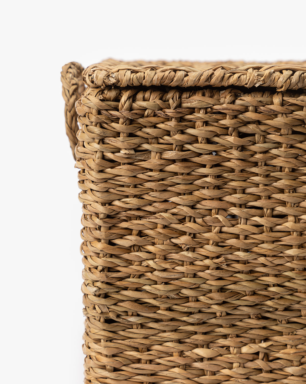 Close-up of the upper corner of the Kya Seagrass Box, showcasing its hand-woven texture and intricate pattern, set against a white background, by Vendixs