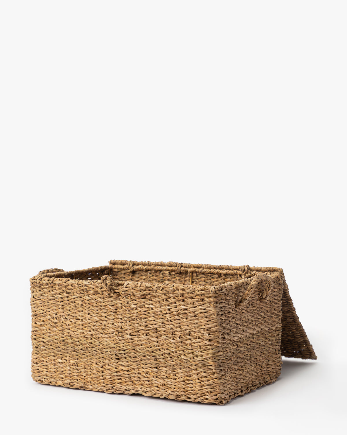 The Kya Seagrass Box is a rectangular, hand-woven basket made from natural fibers with an open lid, displayed on a plain white background—perfect for stylish decorative storage or as a chic seagrass box by Vendixs