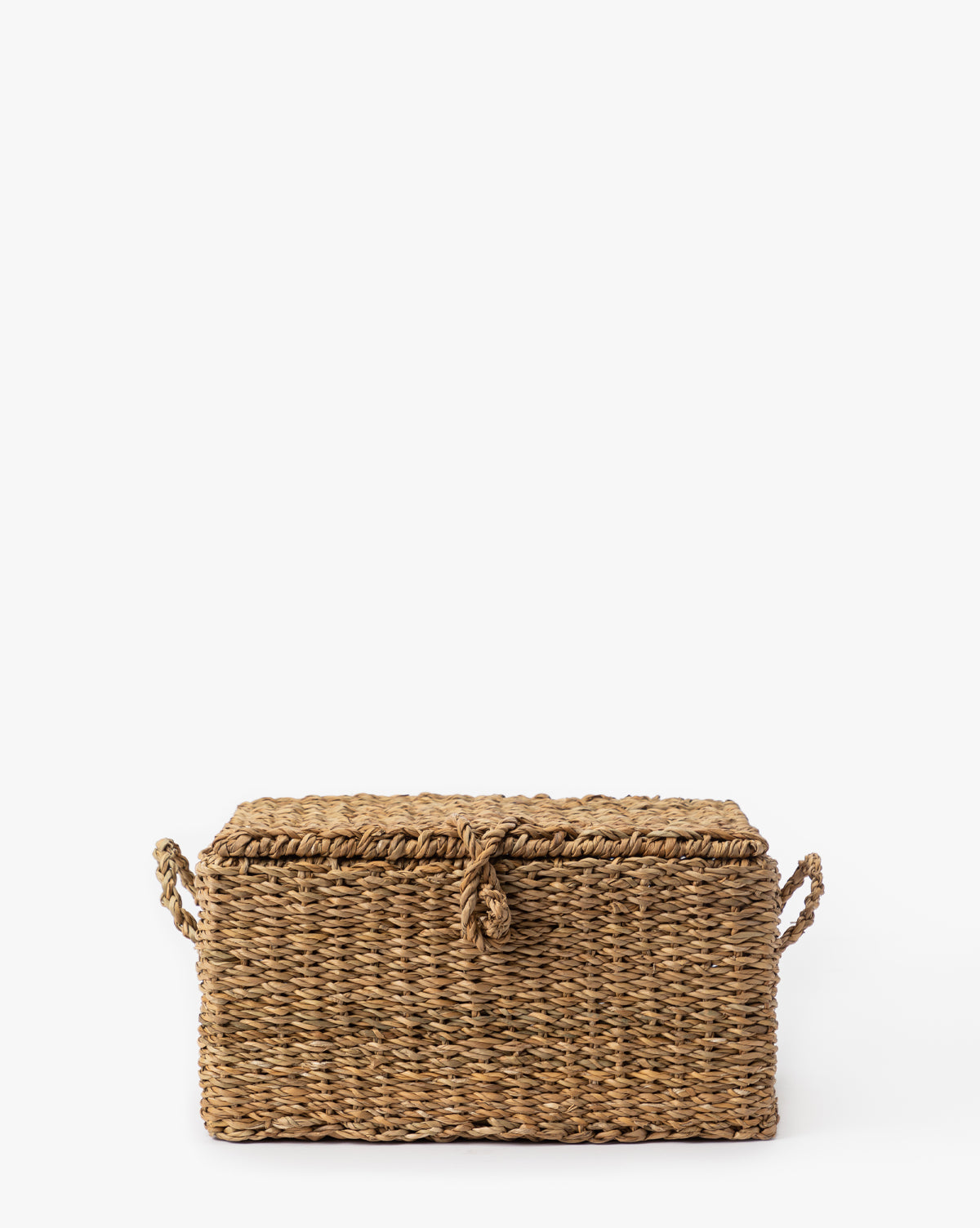 The Kya Seagrass Box is a rectangular, hand-woven basket with a lid and two side handles, crafted from natural fibers—an ideal decorative storage piece for your home, by Vendixs