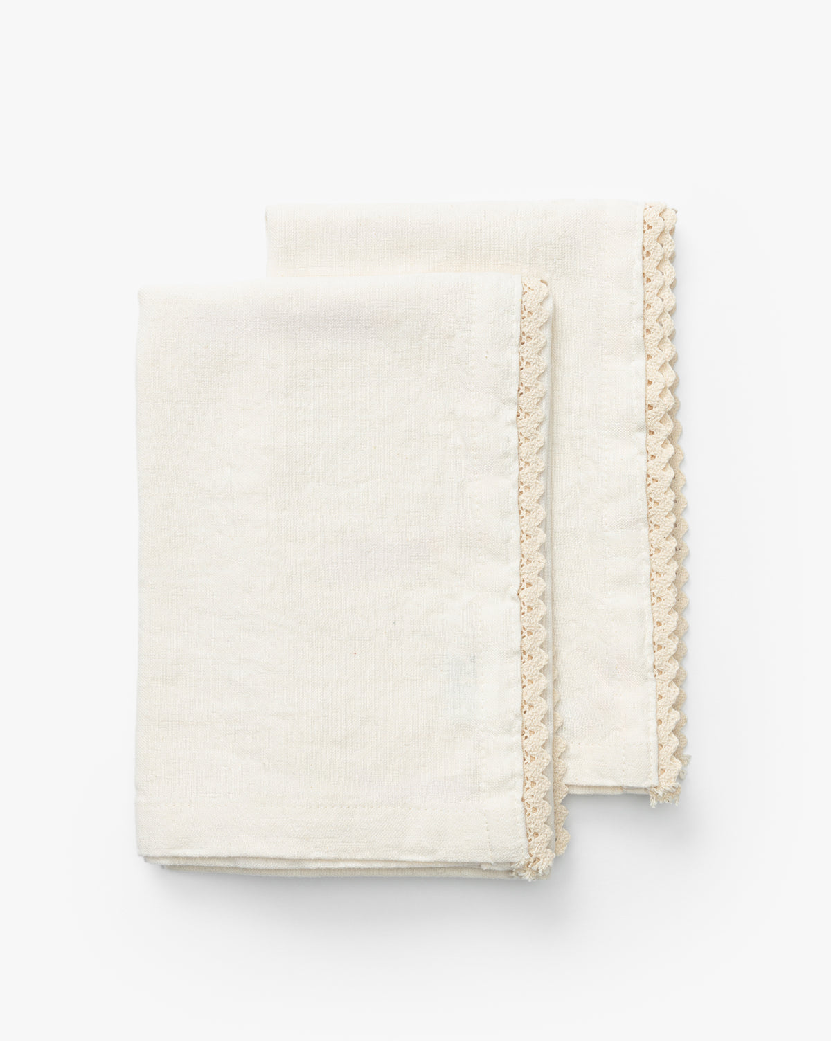 The Lace Tea Towels (Set of 2) are folded side by side on a white background, featuring an off-white cotton-linen blend and delicate beige lace trim along one edge, by Vendixs