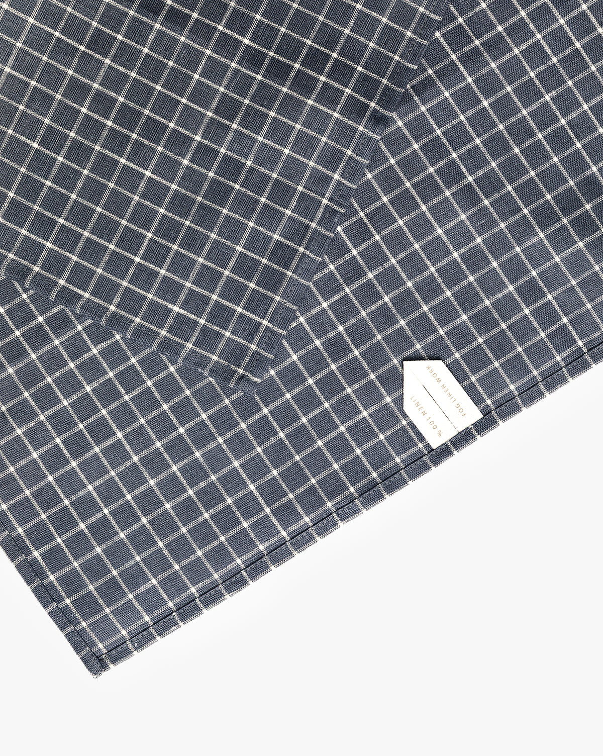 A close-up of the Lancaster Linen Tea Towel, neatly folded in a navy and white check pattern with a white label in the bottom right corner—a timeless kitchen essential, by Vendixs