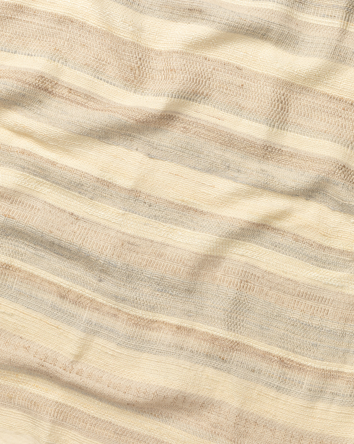 The Laney Stripe Throw by TAL HANDWOVEN CLASSICS LLP features beige and cream woven fabric with subtle horizontal stripes and a textured finish—ideal for adding elegance and warmth to any space. Vendixs