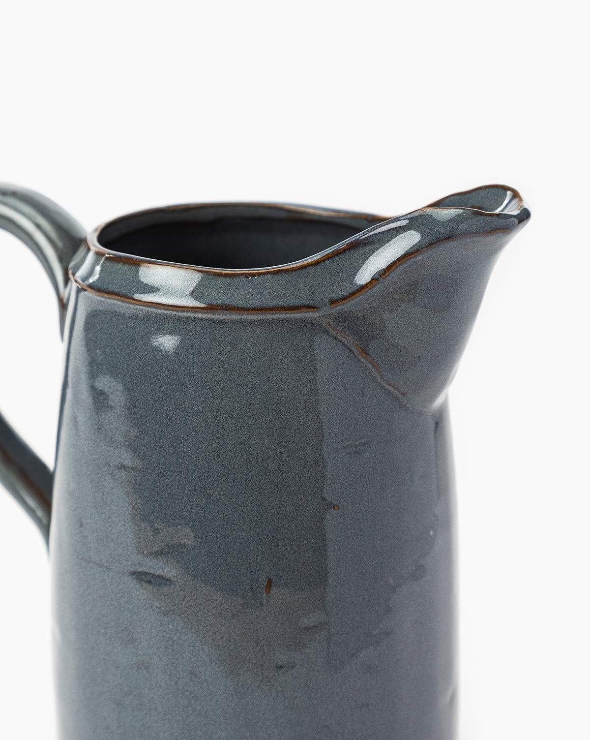 A close-up of the Levine Ceramic Pitcher in deep blue with a glossy dark gray glaze, highlighting its handle and spout against a white background—ideal for modern kitchen decor, by Vendixs