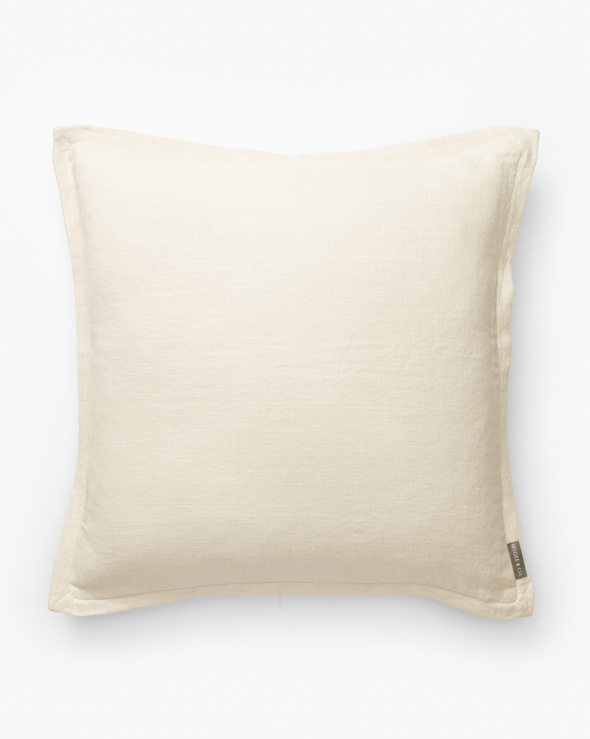 The Liam Double Flange Pillow Cover is a square, off-white decorative cover with a simple design, subtle fabric texture, and refined linen finish. It features a small fabric tag on one edge and is displayed against a plain white background, by Vendixs
