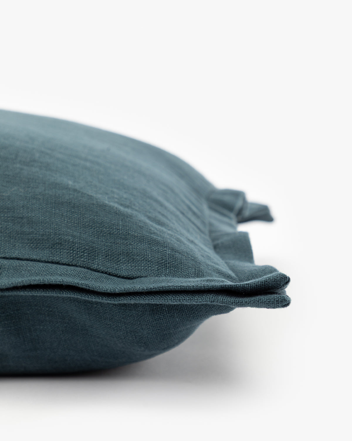 Close-up of the Liam Double Flange Pillow Cover in dark teal, featuring layered double flange edges. Part of the linen cover is shown against a white background, highlighting its texture and fabric details by Vendixs