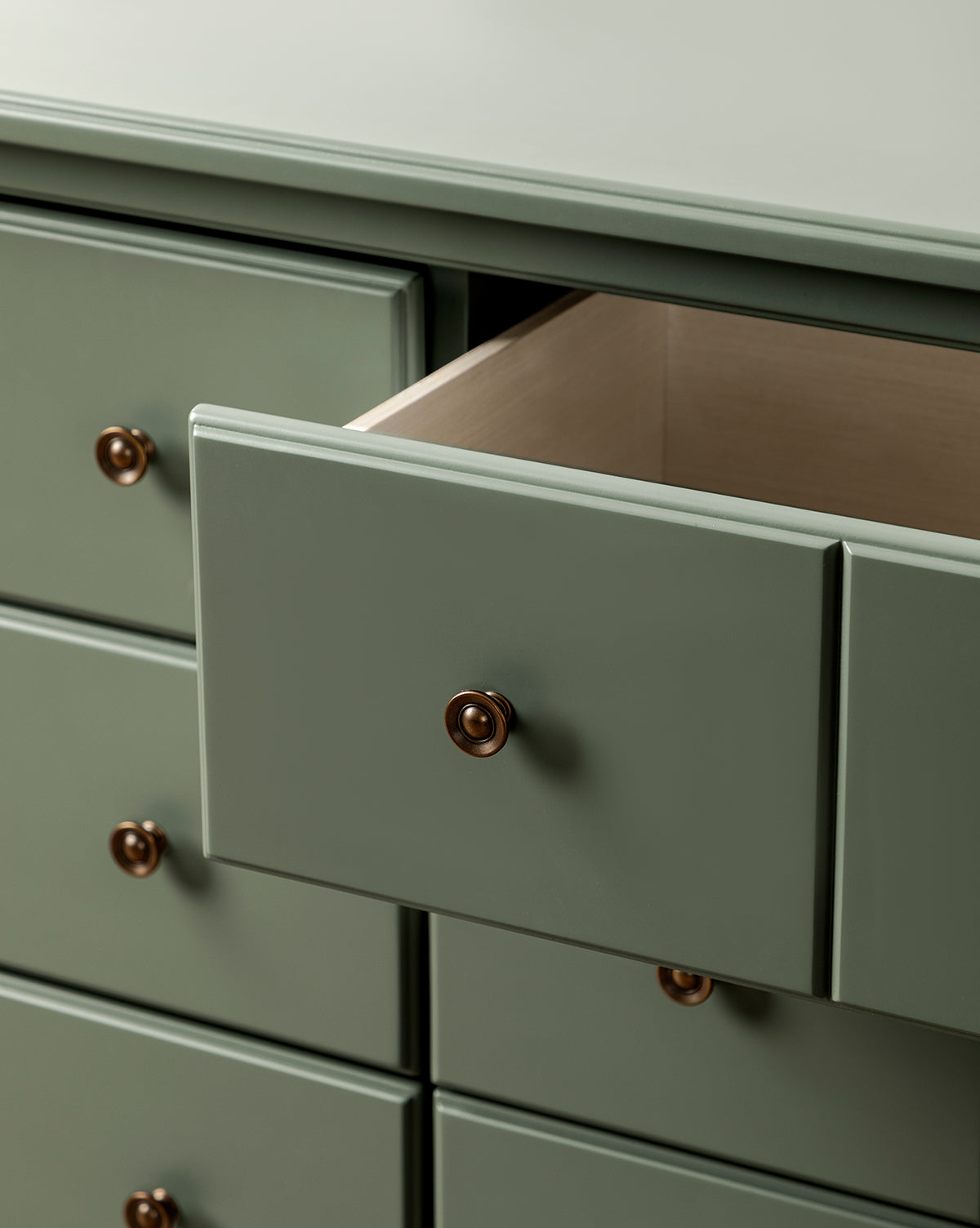 The Liberty 6-Drawer Assembled Dresser features gold knobs and a vintage design, with one drawer partially open to display its empty, sustainable pine wood interior, by Vendixs