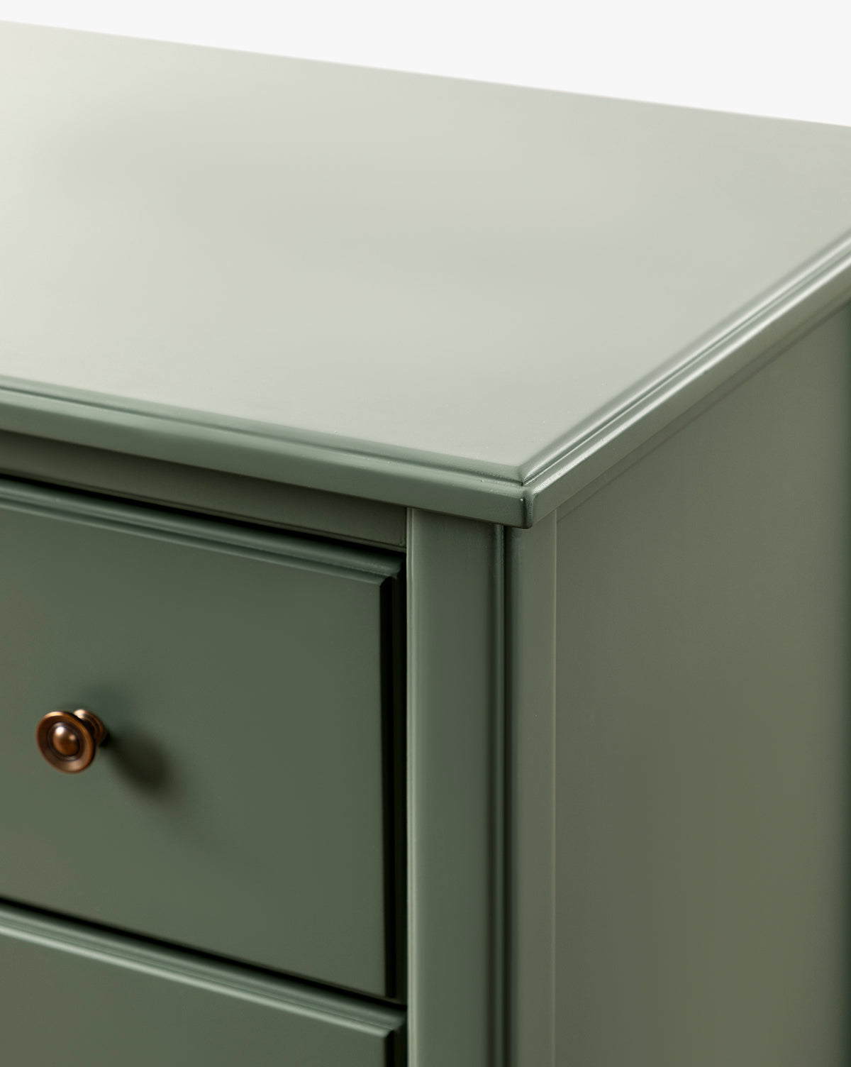 Close-up of the top corner and side of the Liberty 6-Drawer Assembled Dresser, crafted from sustainable pine wood with a smooth green finish, showing part of a drawer and its round, dark-colored knob, by Vendixs