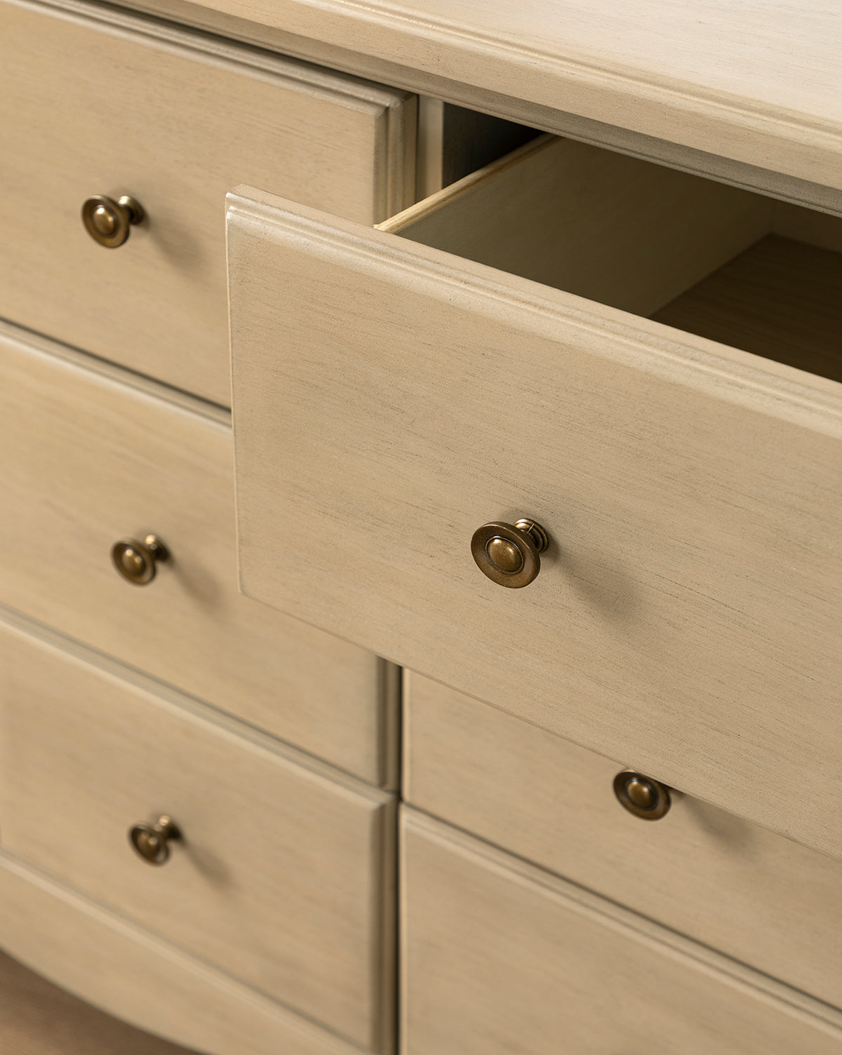 Close-up of the Liberty 6-Drawer Assembled Dresser, made from sustainable pine wood with round brass knobs. One spacious drawer is slightly open, showing an empty interior. The dresser features a smooth finish and multiple roomy drawers by Vendixs