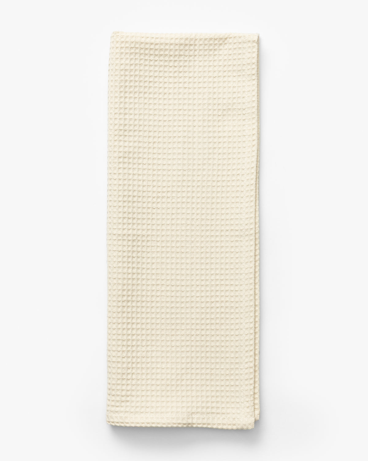 The Linen Blend Waffle Tea Towel, featuring a waffle weave texture in off-white, is folded neatly on a white background—an absorbent kitchen essential, by Vendixs