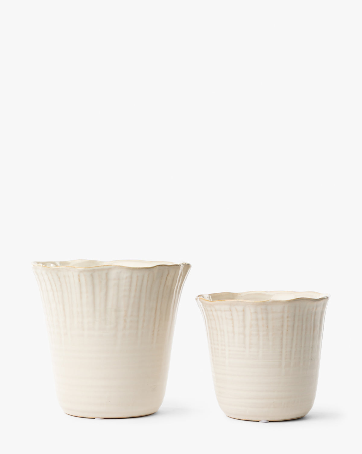 The London Planters (Set of 2) by Napa Home & Garden features cream-colored ceramic pots with scalloped edges and vertical textured lines, in two sizes, shown on a plain white background. Vendixs