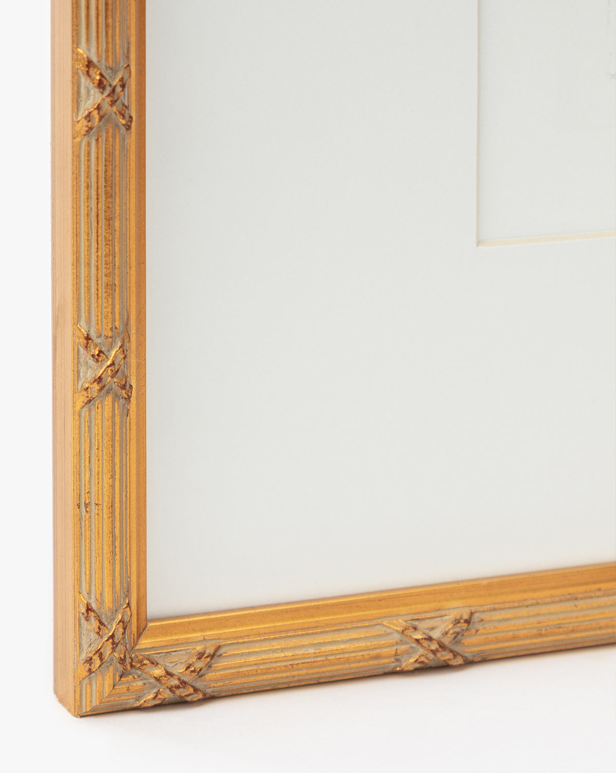 Close-up of the Loose Ribbons golden frame featuring a ribbed texture and crisscross corners, ideal for displaying giclee prints or artwork in a childs room, shown with a white mat board, by Vendixs