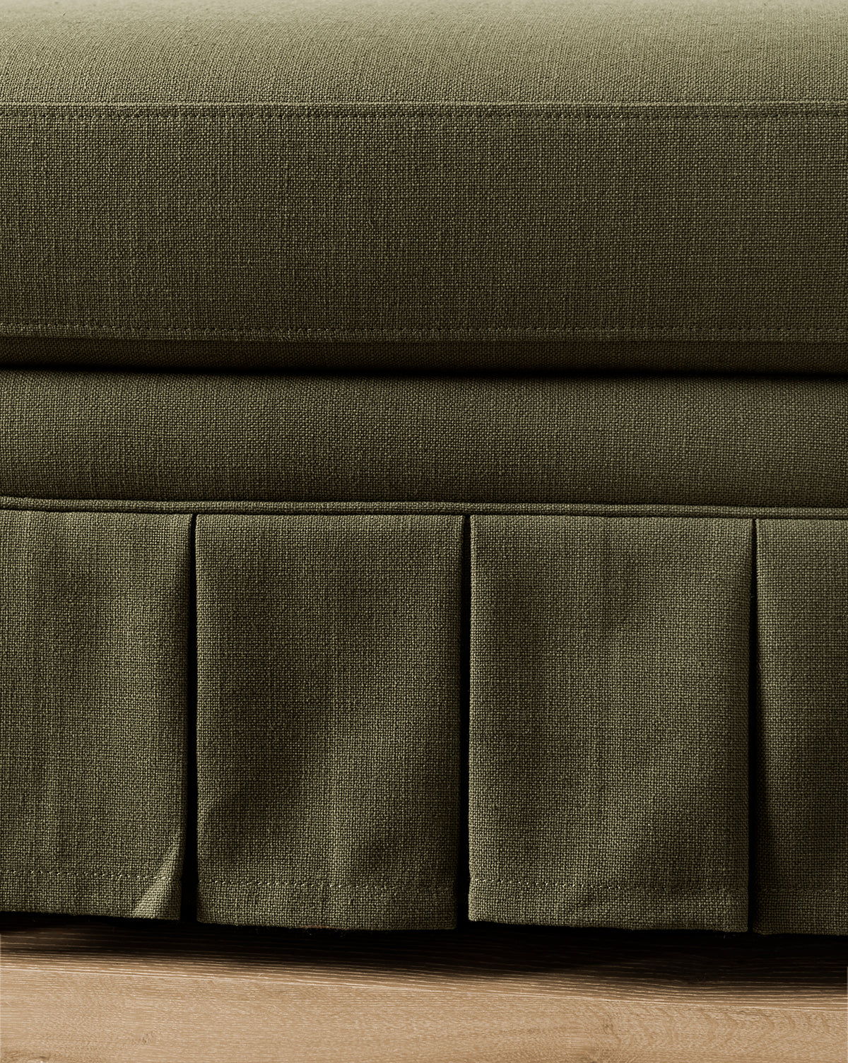 Close-up of a green fabric bed skirt on a bed with wooden flooring from Vendixs