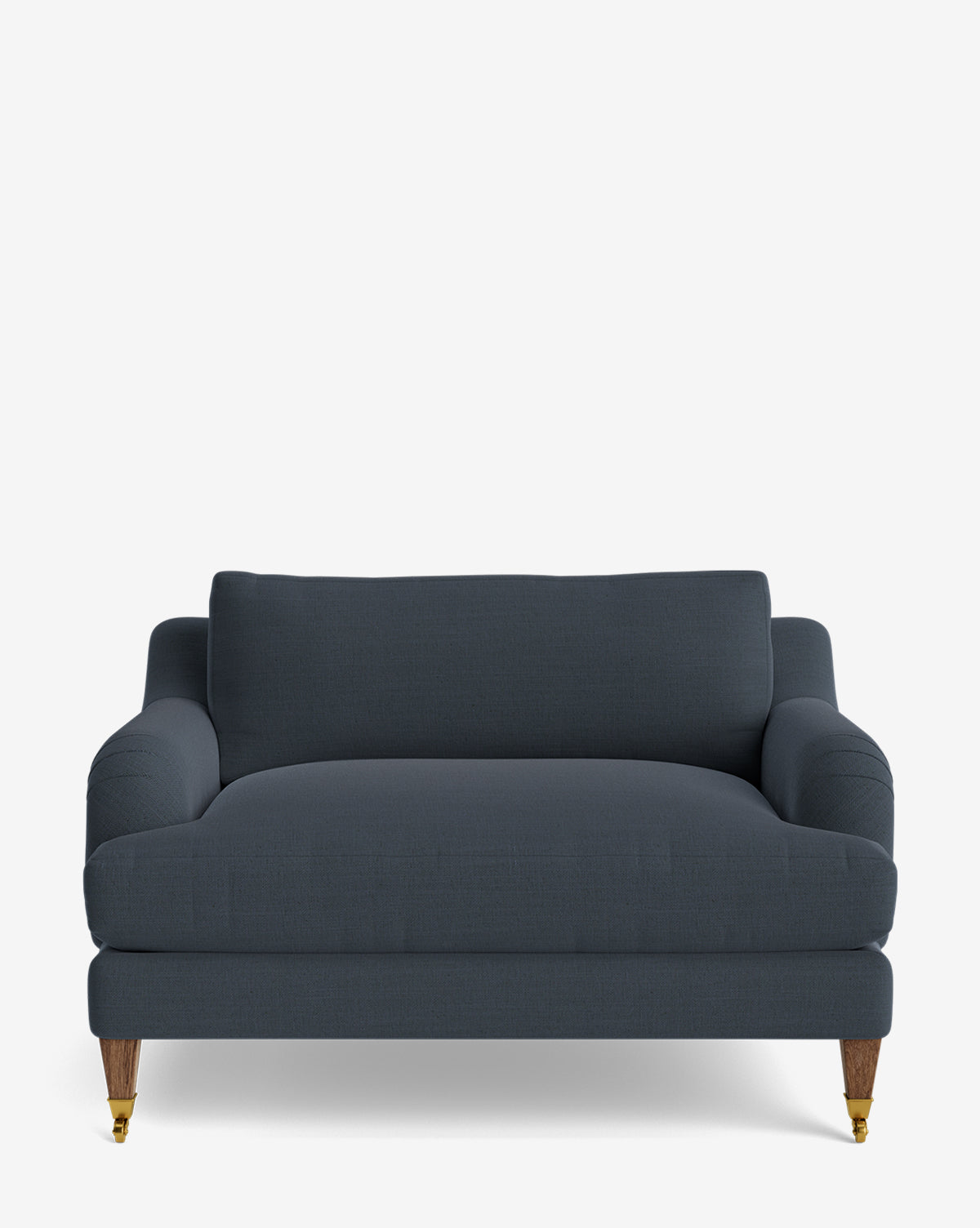 The Lucille English Roll Arm Chair and a Half is a dark blue upholstered loveseat with rounded arms, down-wrapped cushions, wooden legs, and front brass casters, shown against a plain white background by McGee & Co.