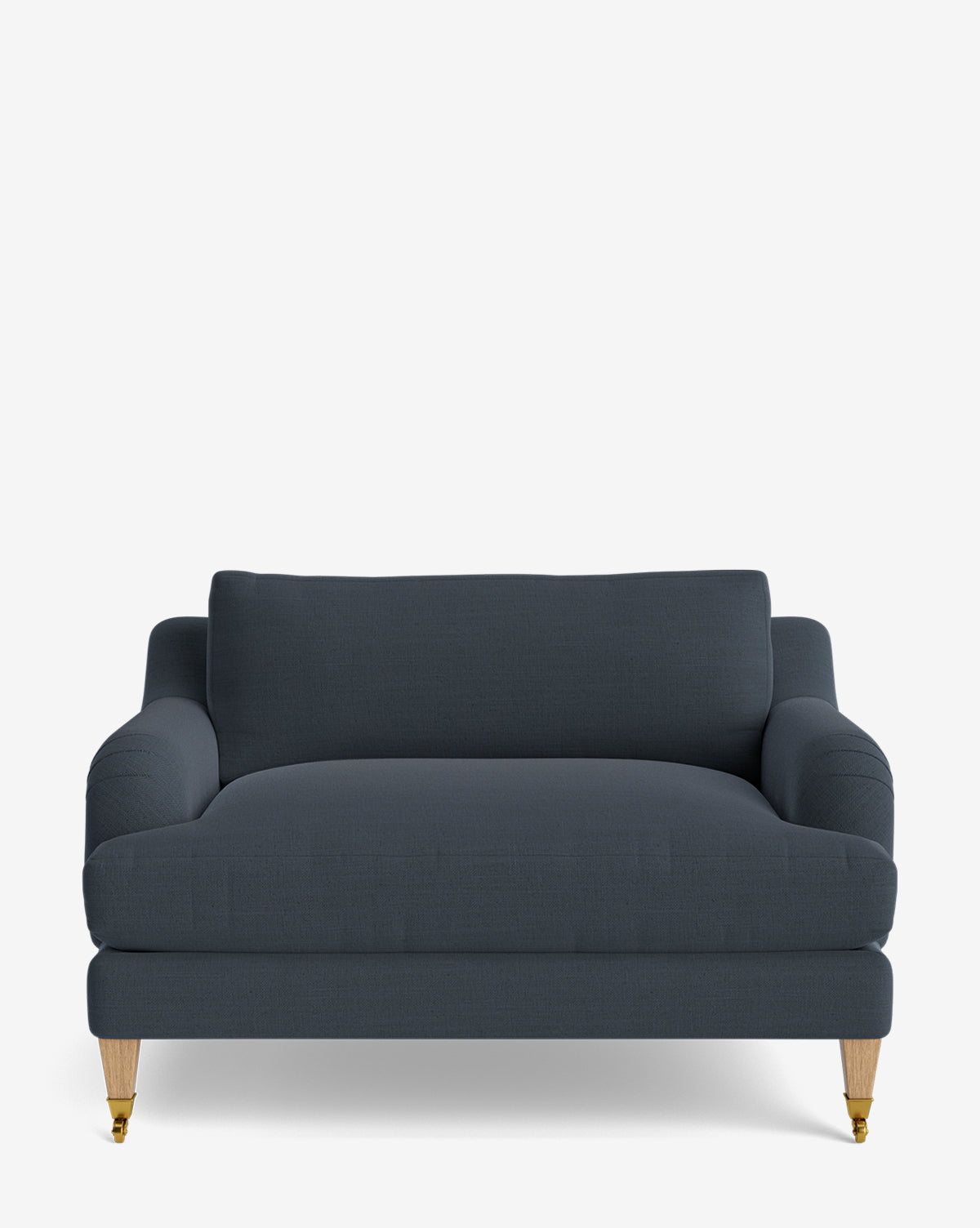 The Lucille English Roll Arm Chair and a Half, in dark blue upholstery, features rounded arms, wooden legs with brass castors at the front, and a down-wrapped cushion for extra comfort against a plain white background by McGee & Co.